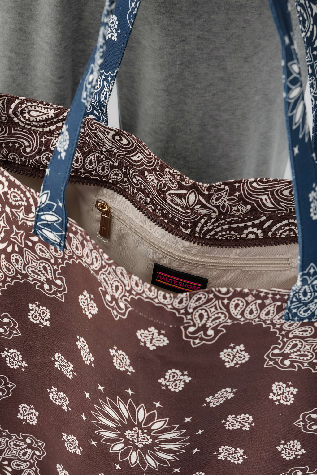 Bandana print tote bag with front zip pocket and brown-and-navy paisley pattern