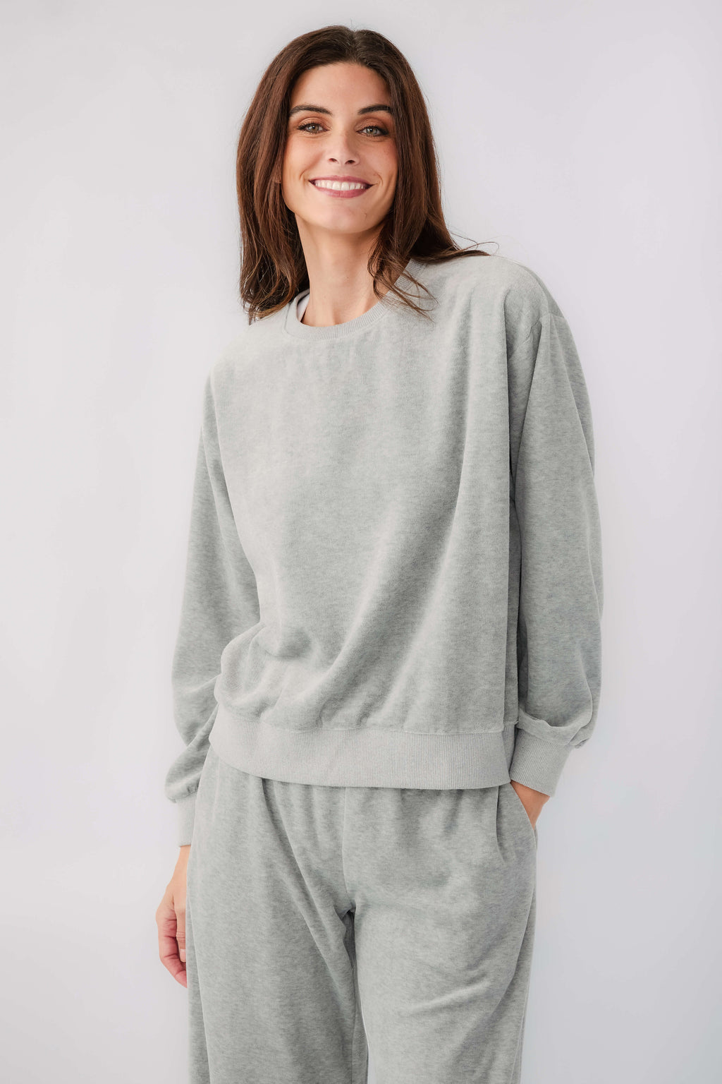 Grey velour sweatshirt with crew neck and long sleeves, paired with drawstring sweatpants