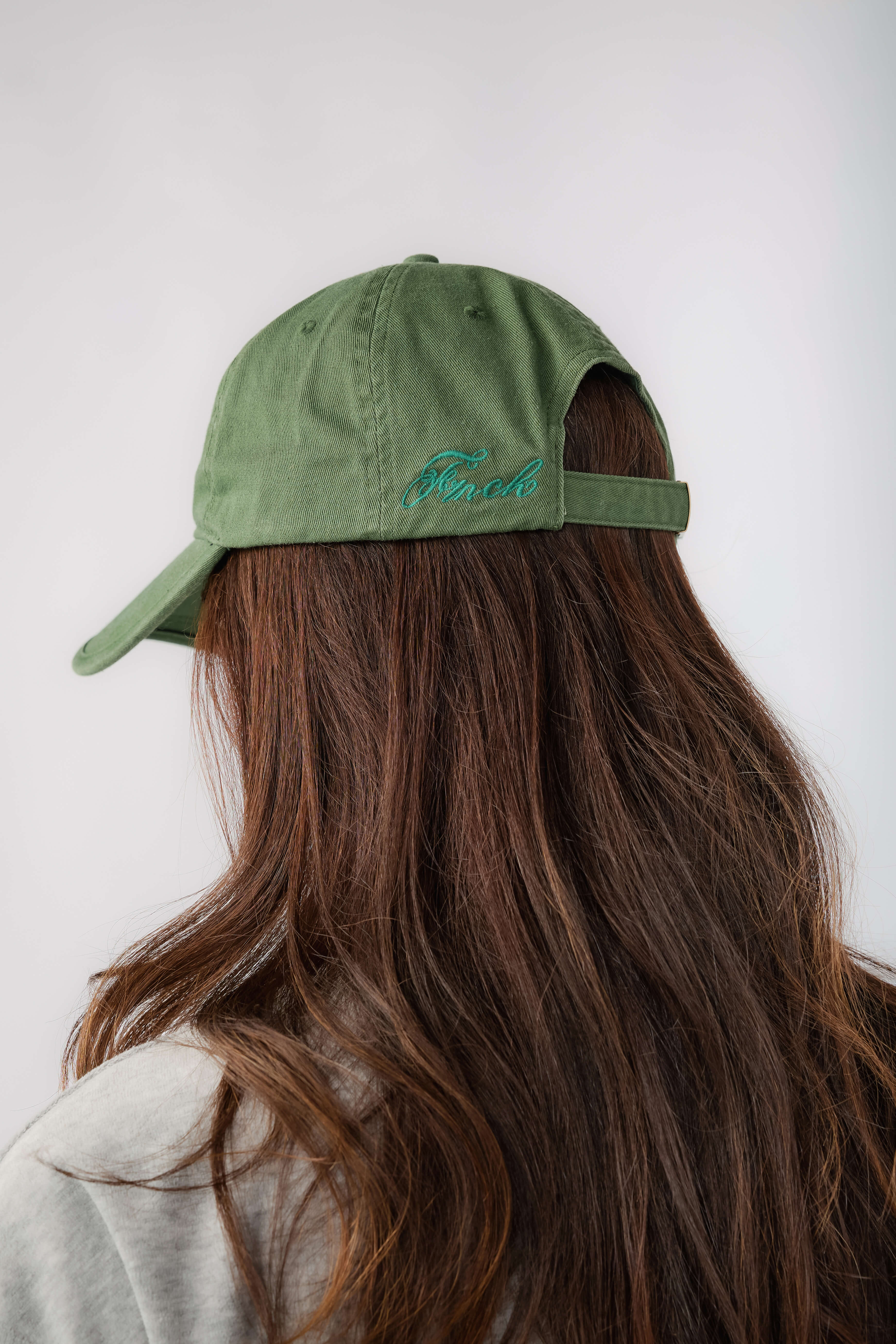 Green baseball cap with blue embroidered back lettering