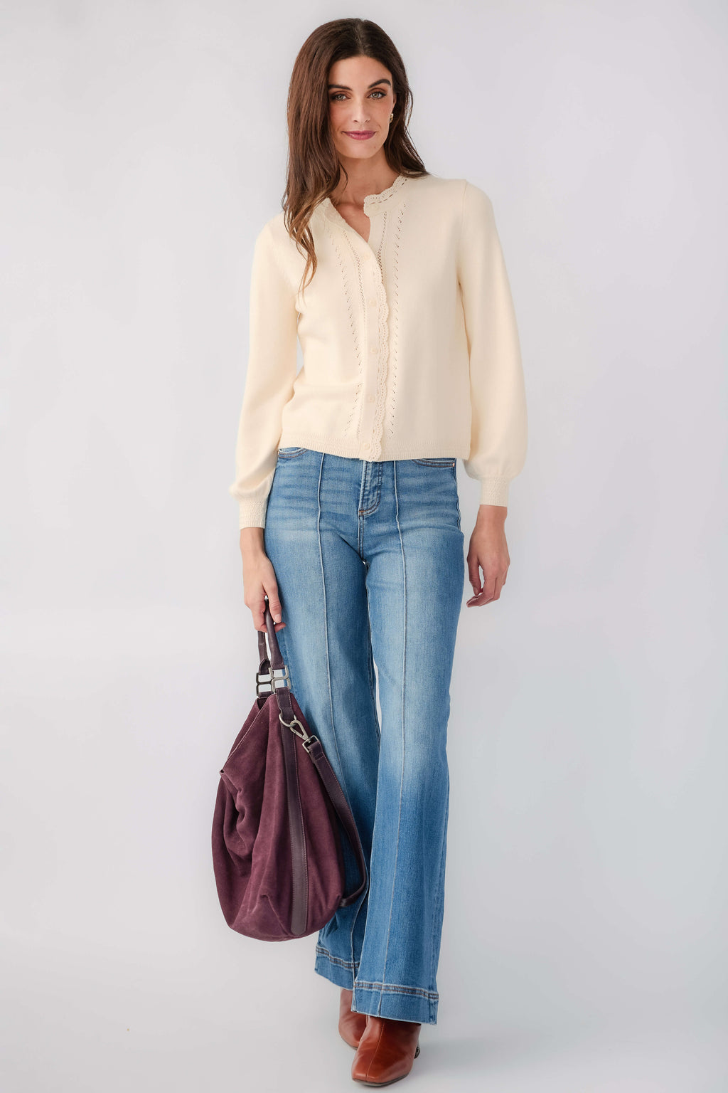 Cream eyelet cardigan with button front and long sleeves, ribbed cuffs