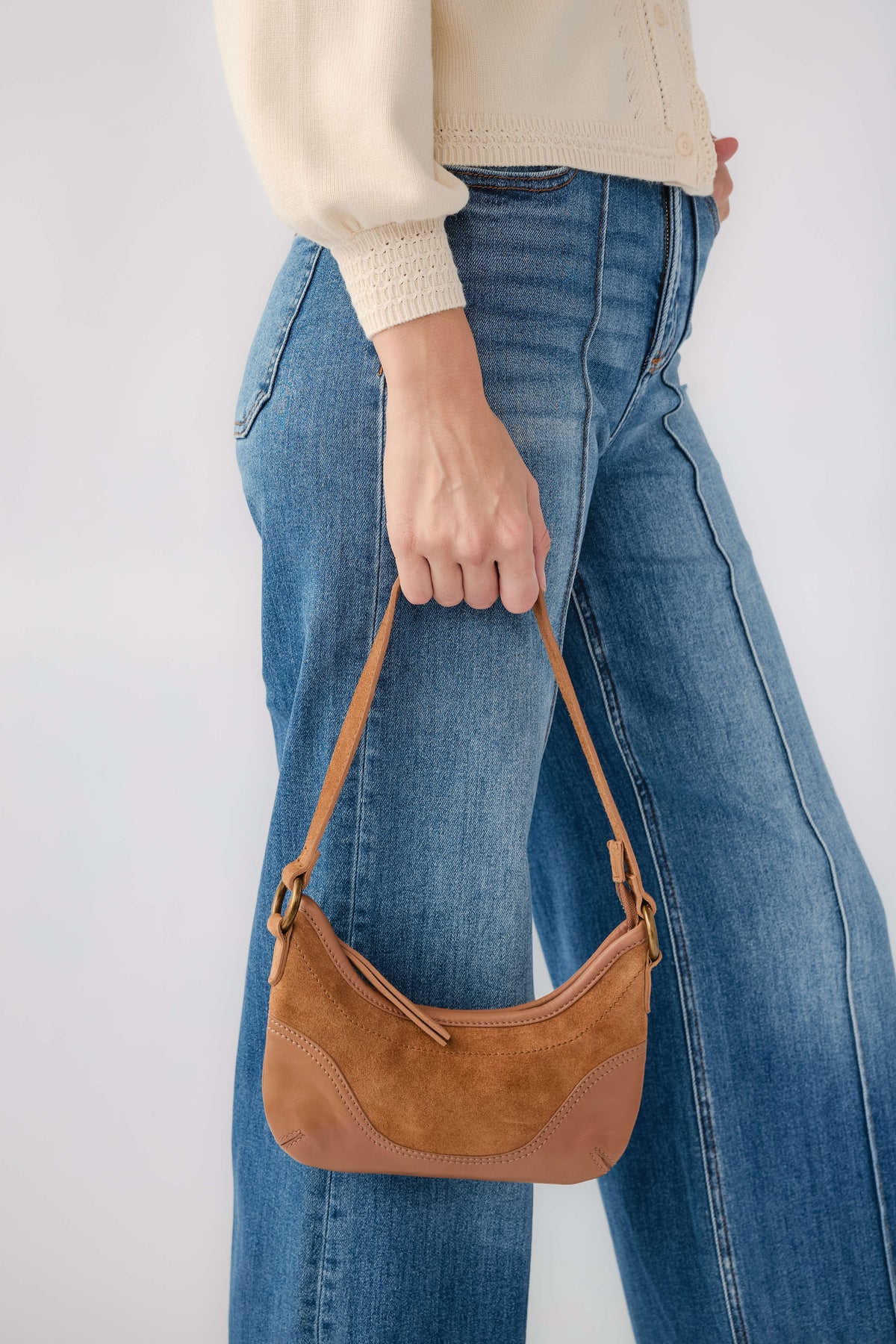 Cognac leather shoulder bag with zip top and braided strap, curved front pocket