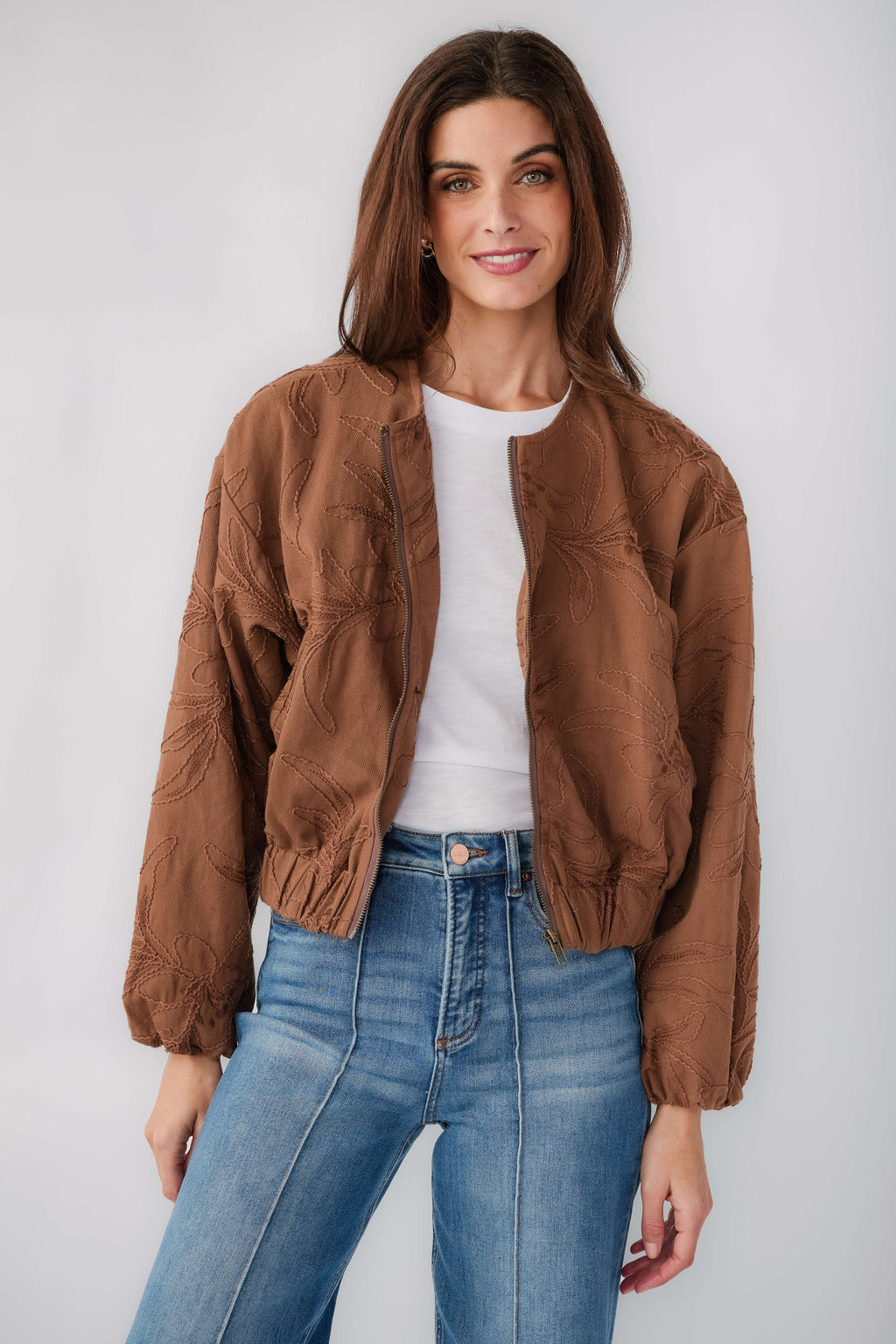 Brown floral jacquard jacket with elastic cuffs and front opening, worn with jeans