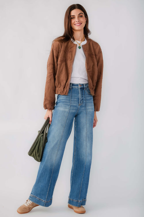 Brown floral jacquard jacket with elastic waistband and cuffs, paired with blue jeans
