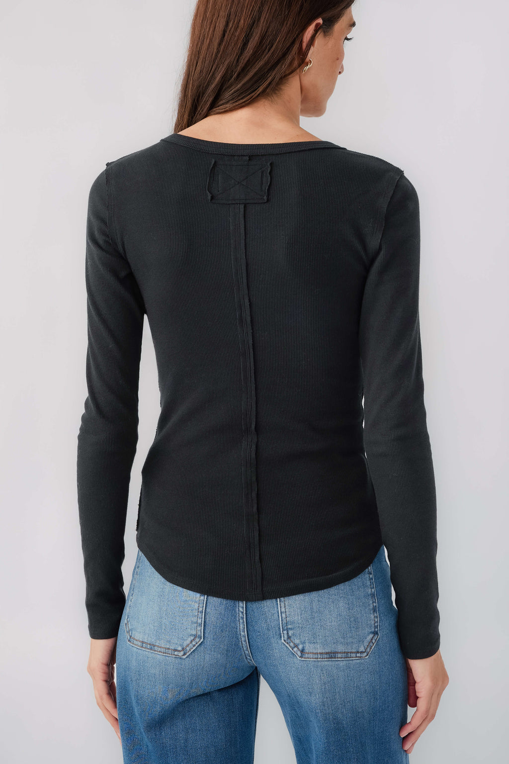 Women's black long-sleeve henley top back view with center seam and neckline yoke
