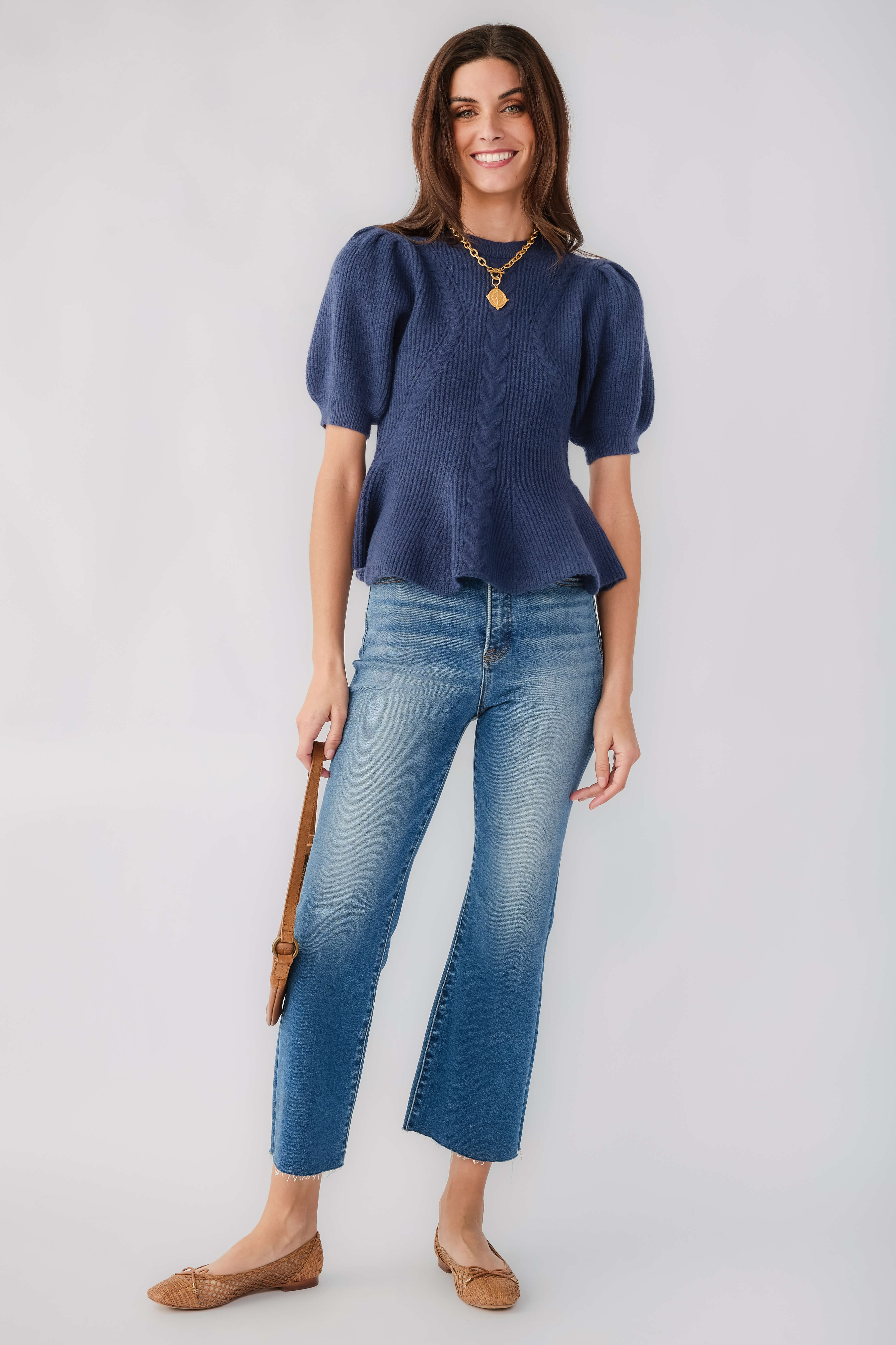 Navy flared knit top with puff sleeves and crew neck, textured cable knit detail