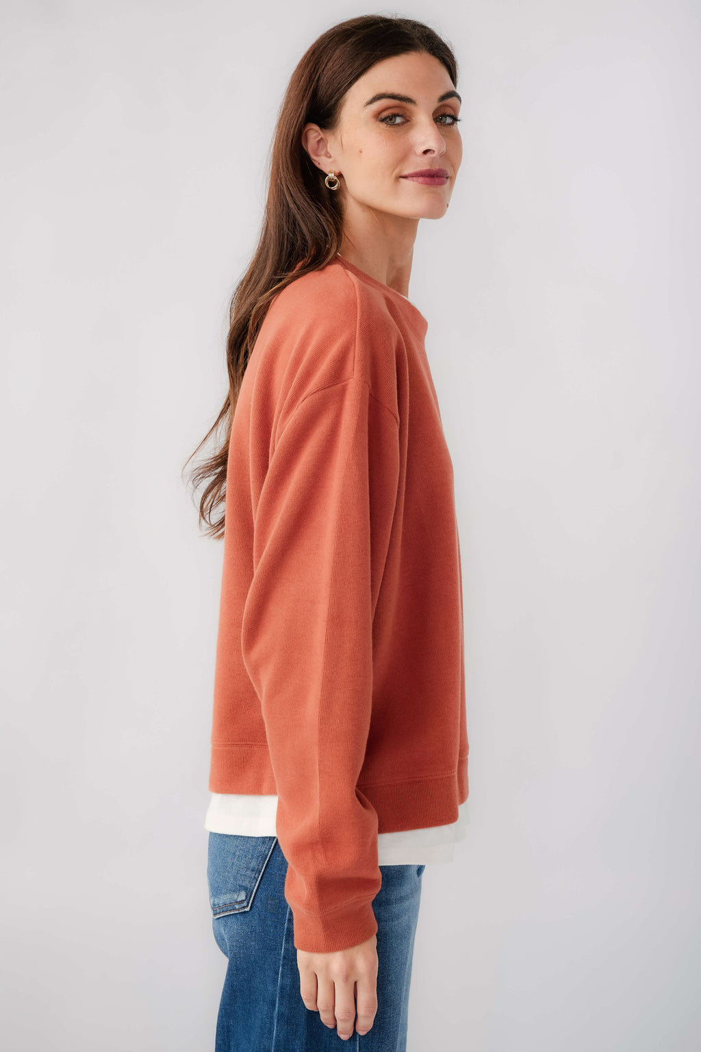 Rust crewneck pullover side view with long sleeves and white hem band