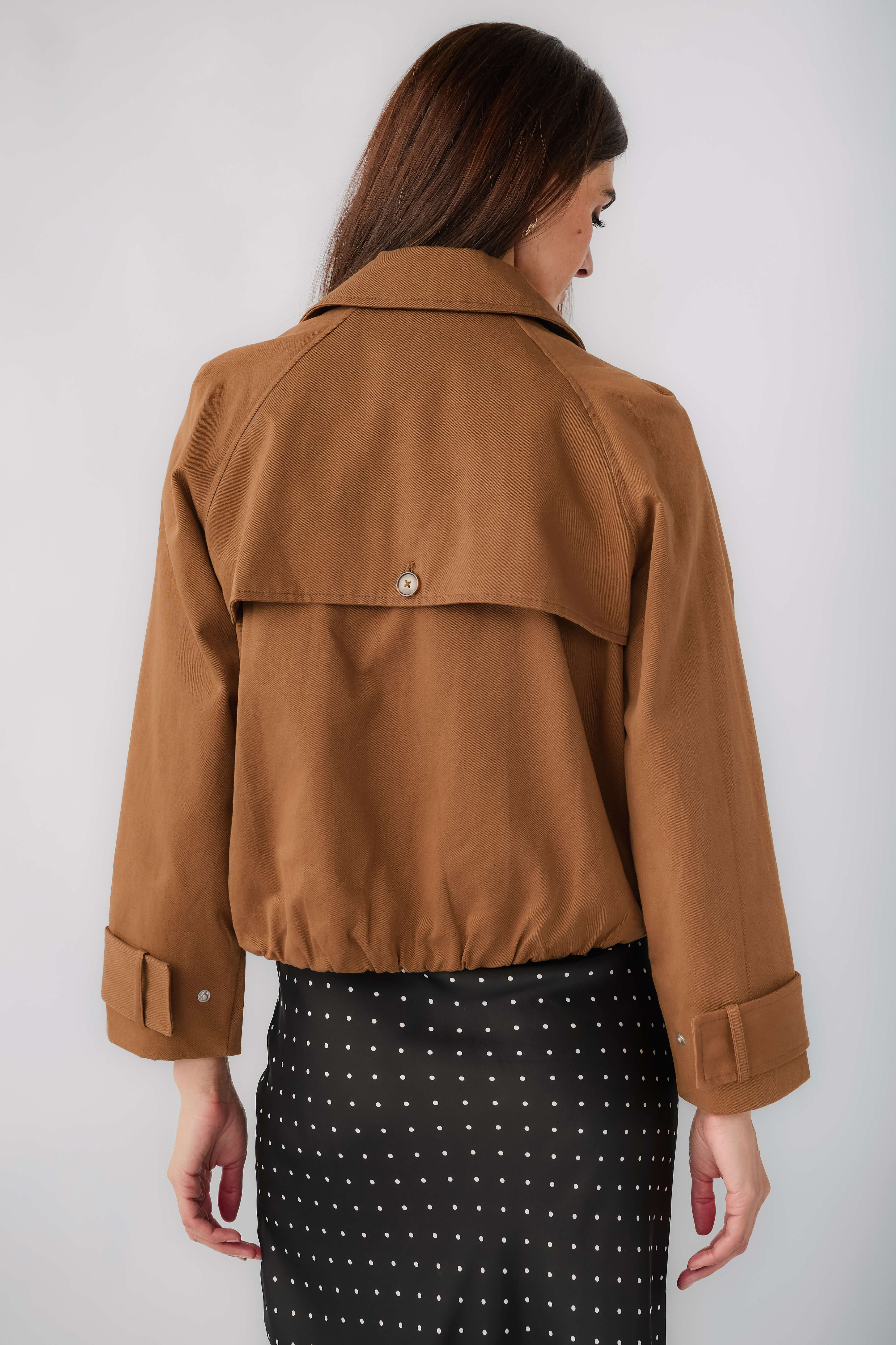 Back view of brown cropped trench jacket with yoke and buttoned collar