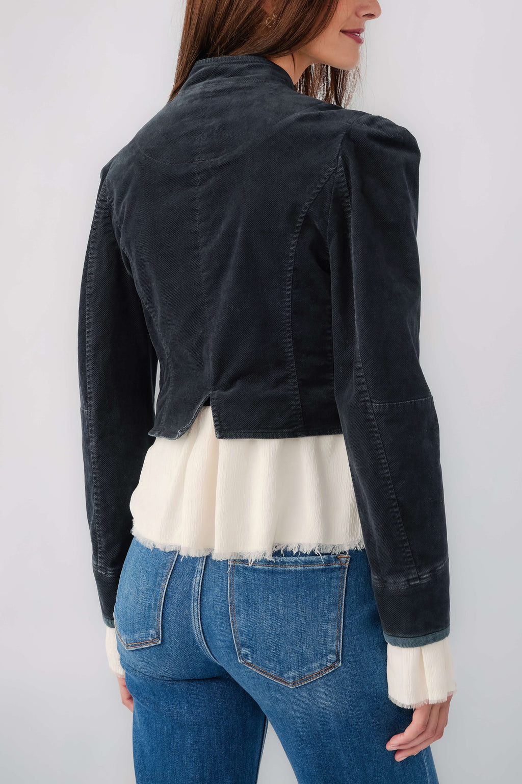 Black denim blazer back view with seams and white ruffled hem