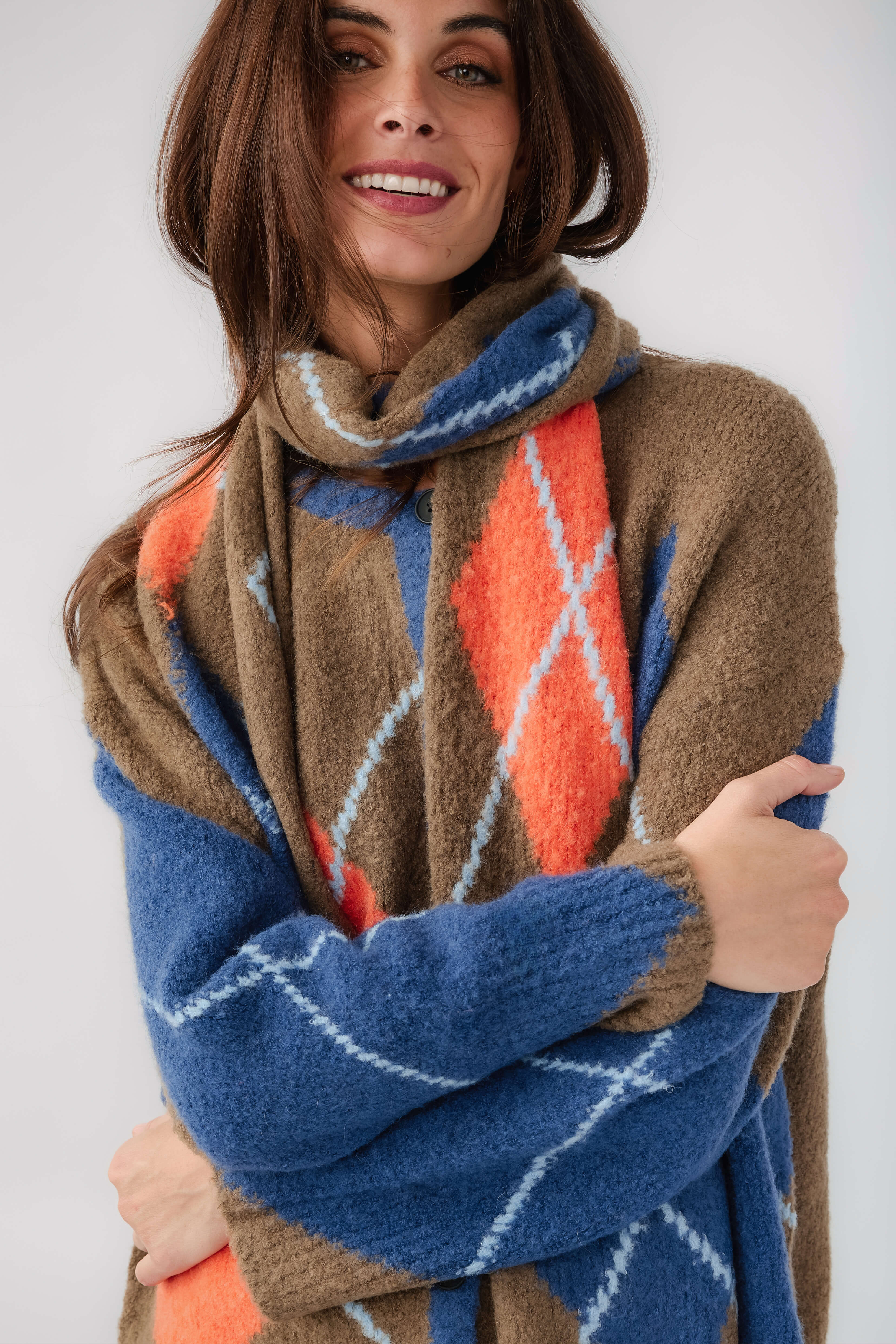 Kaki diamond-pattern scarf with blue and orange accents, wrapped around neck