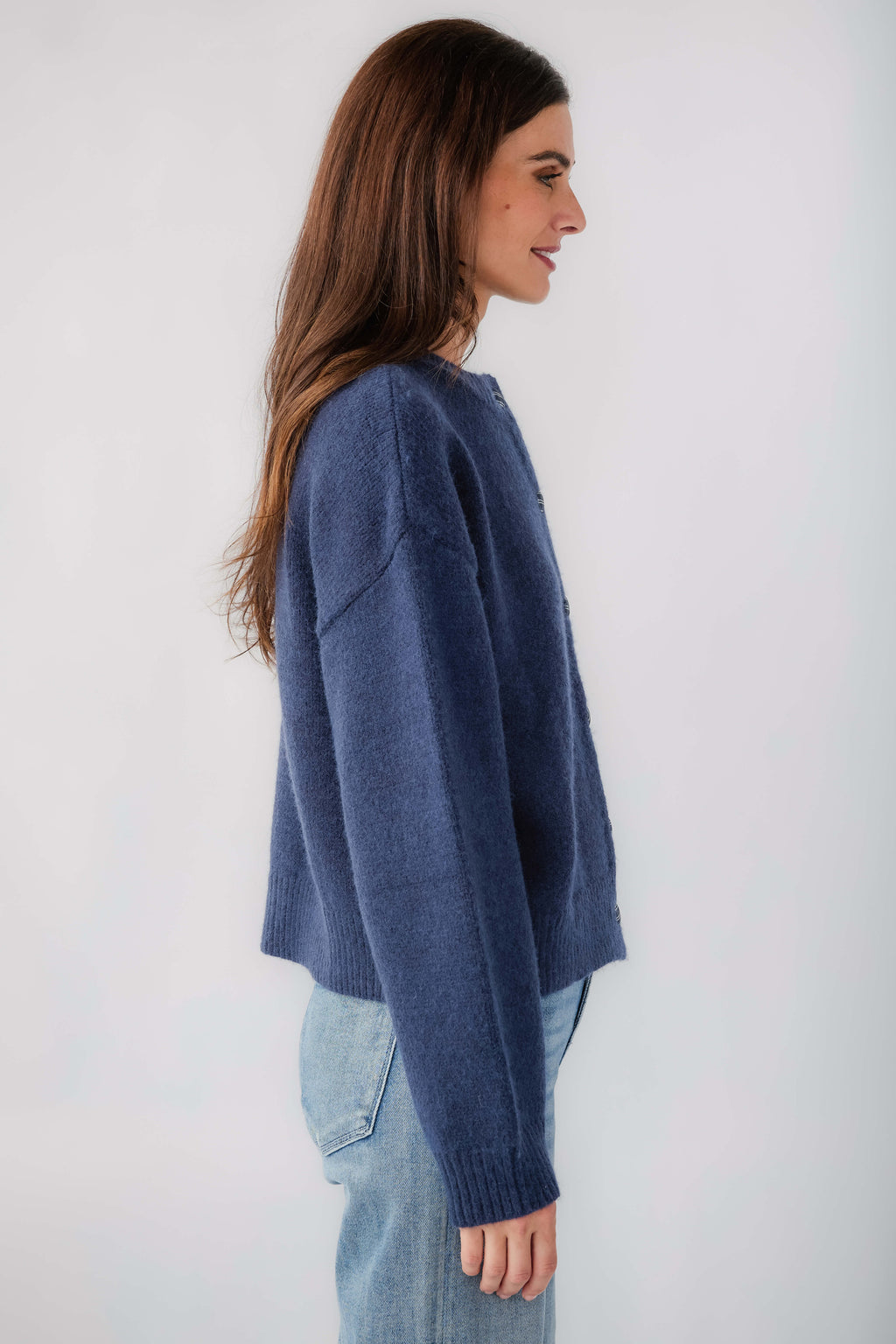 Navy knit cardigan with ribbed cuffs and button placket, side profile