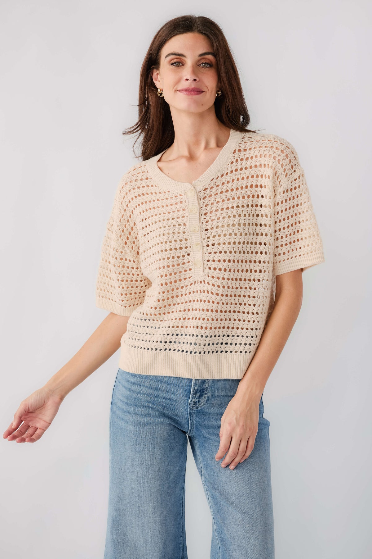 Cream open-knit polo sweater with button front and short sleeves, relaxed fit