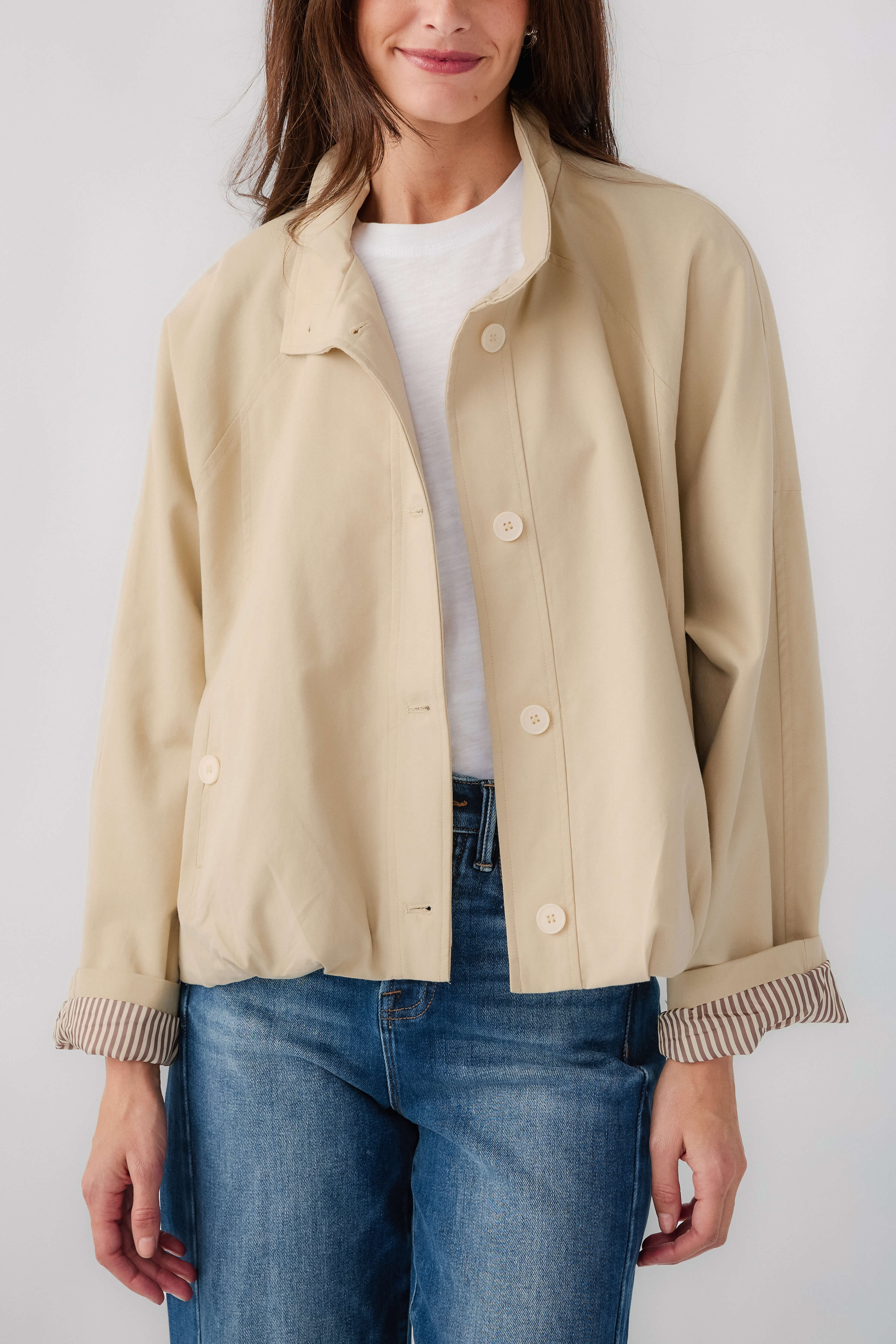 Light beige button-front jacket with stand collar and ribbed striped sleeve cuffs
