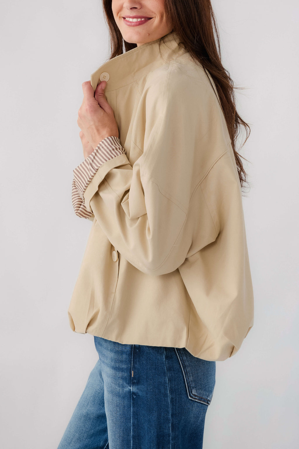 Light beige jacket with stand collar, button placket, and striped ribbed sleeve cuffs