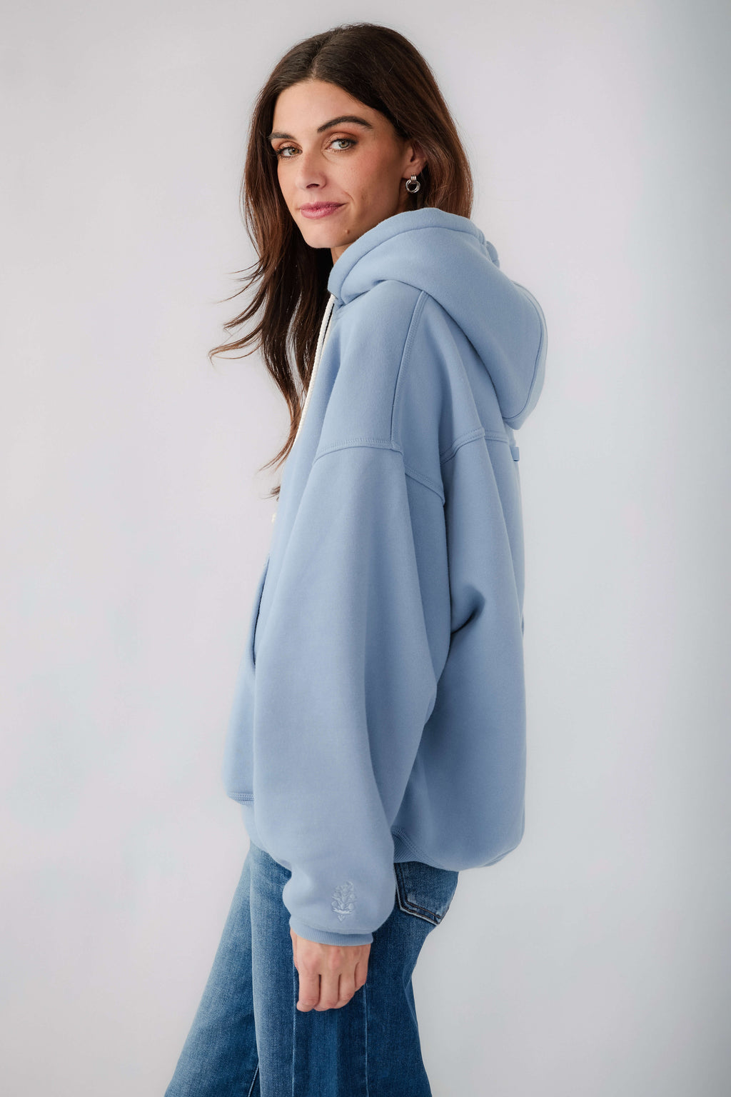 Light blue pullover hoodie with drawstring hood and kangaroo pocket, side view