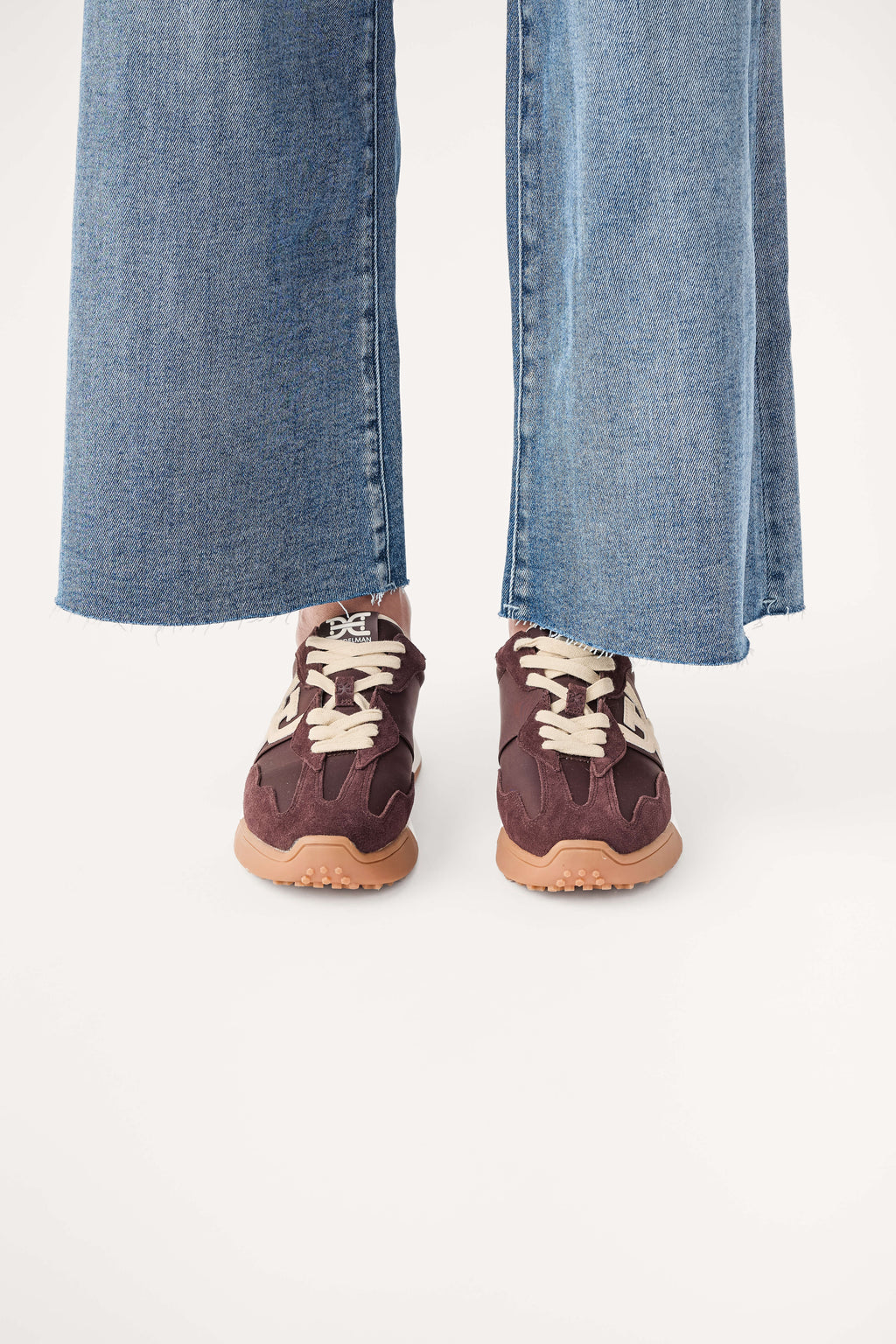 Brown lace-up sneakers with white logo trim and tan rubber sole