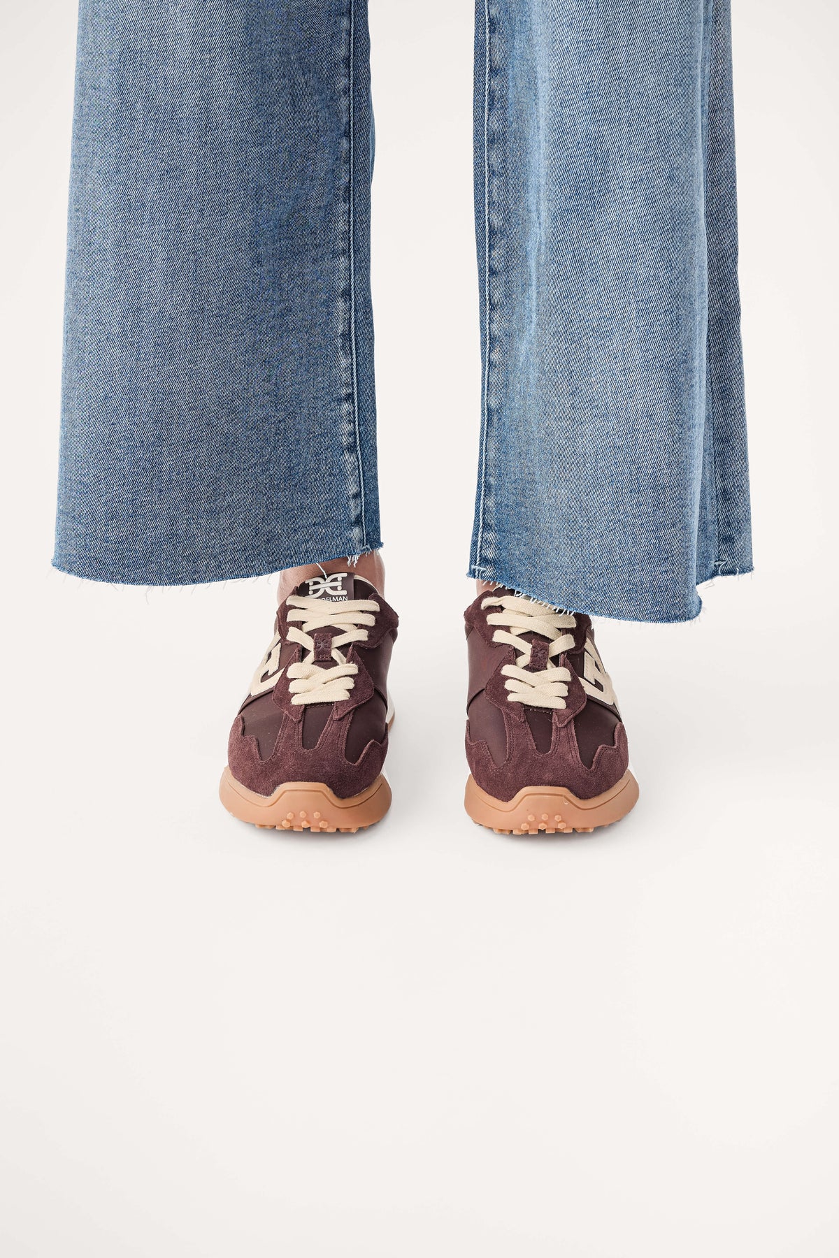 Brown lace-up sneakers with white logo trim and tan rubber sole