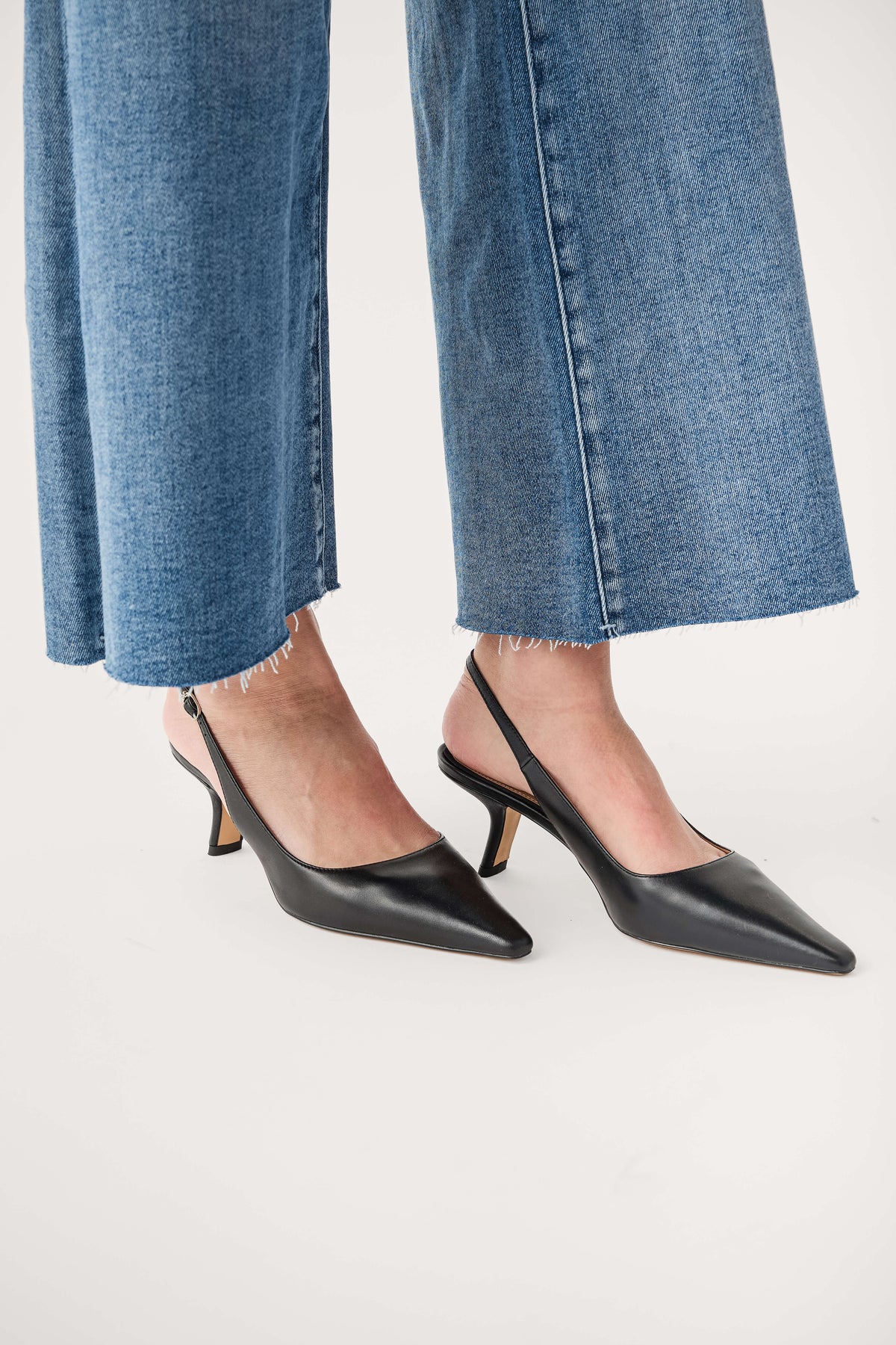 Black pointed-toe slingback pump with thin heel, side view.