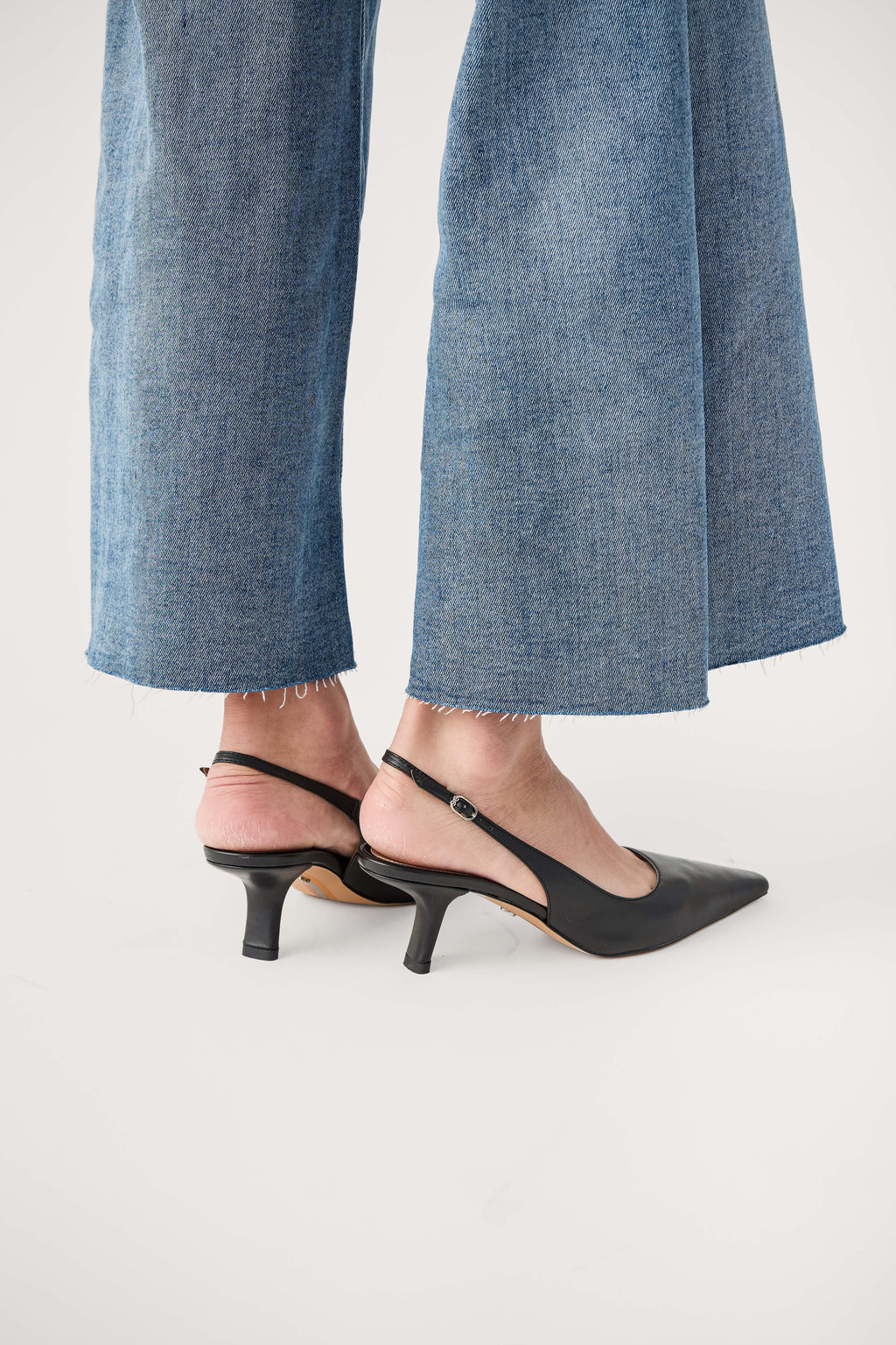 Black leather slingback pump with low pointed heel, back quarter view.