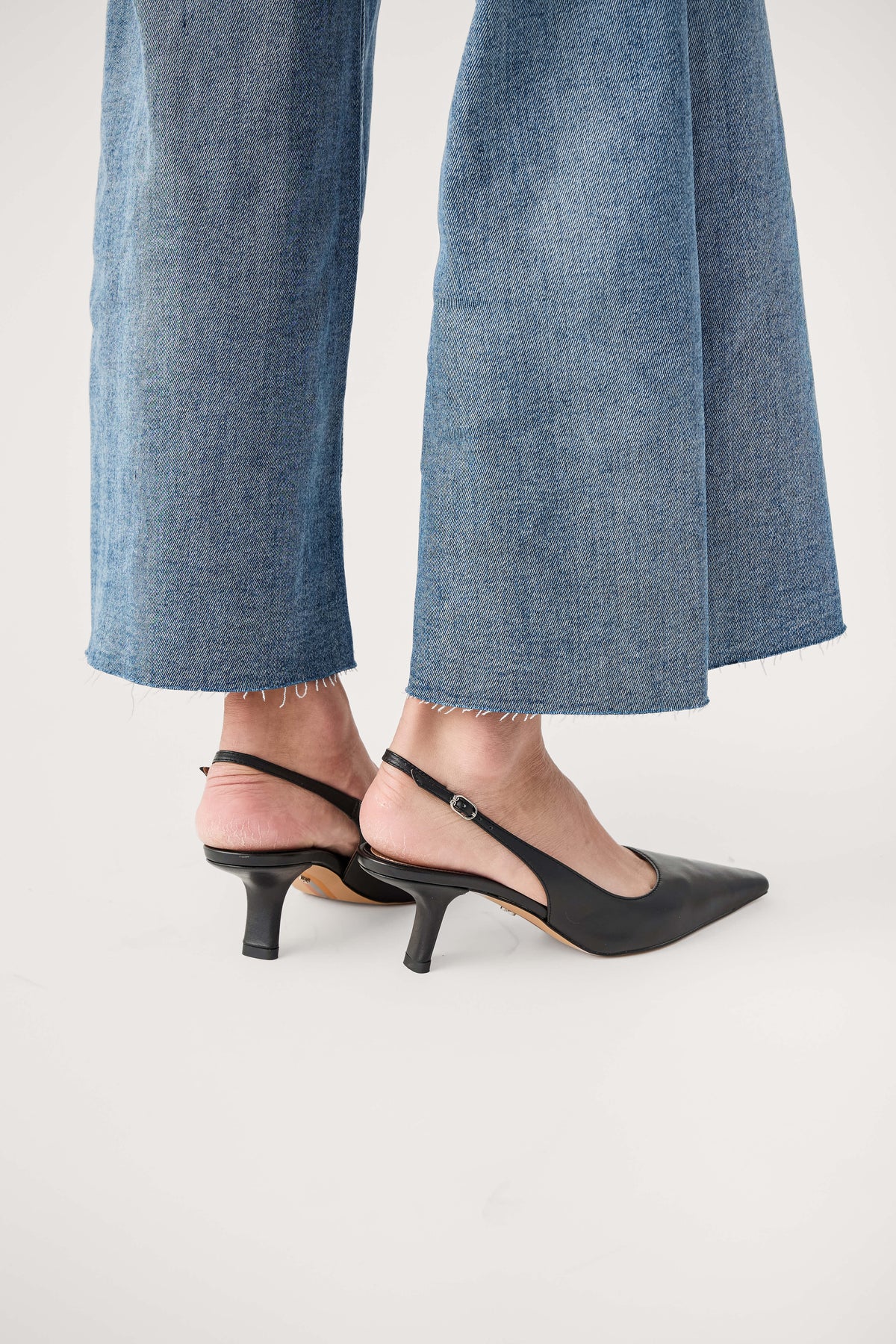 Black leather slingback pump with low pointed heel, back quarter view.