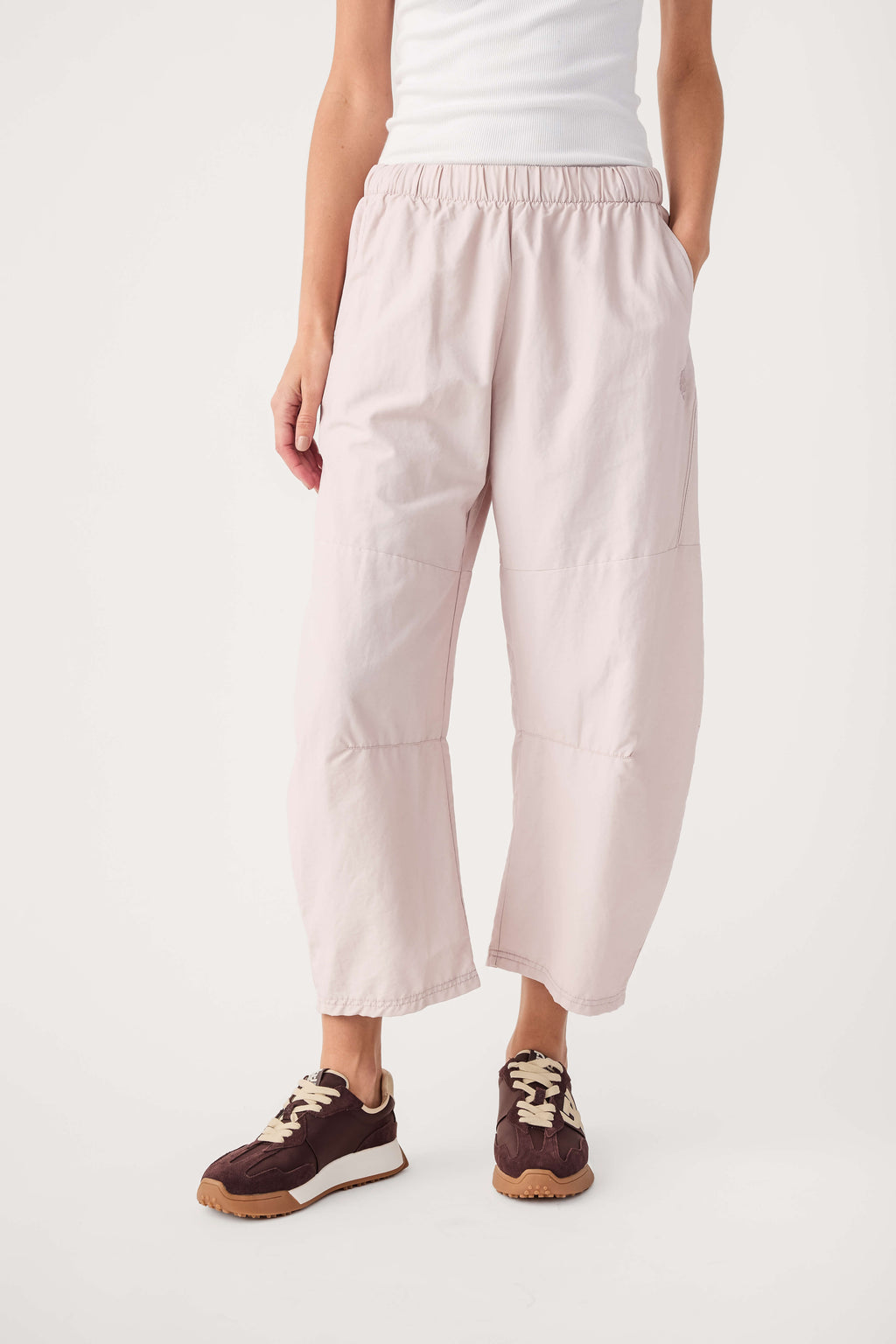 Light pink tapered jogger pants with elastic waistband and side pockets