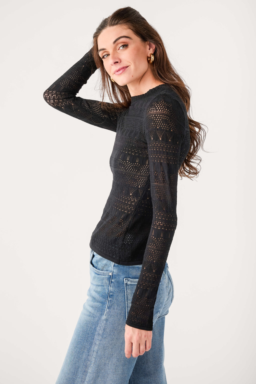 Black knit sweater top with long sleeves and allover perforated lace pattern