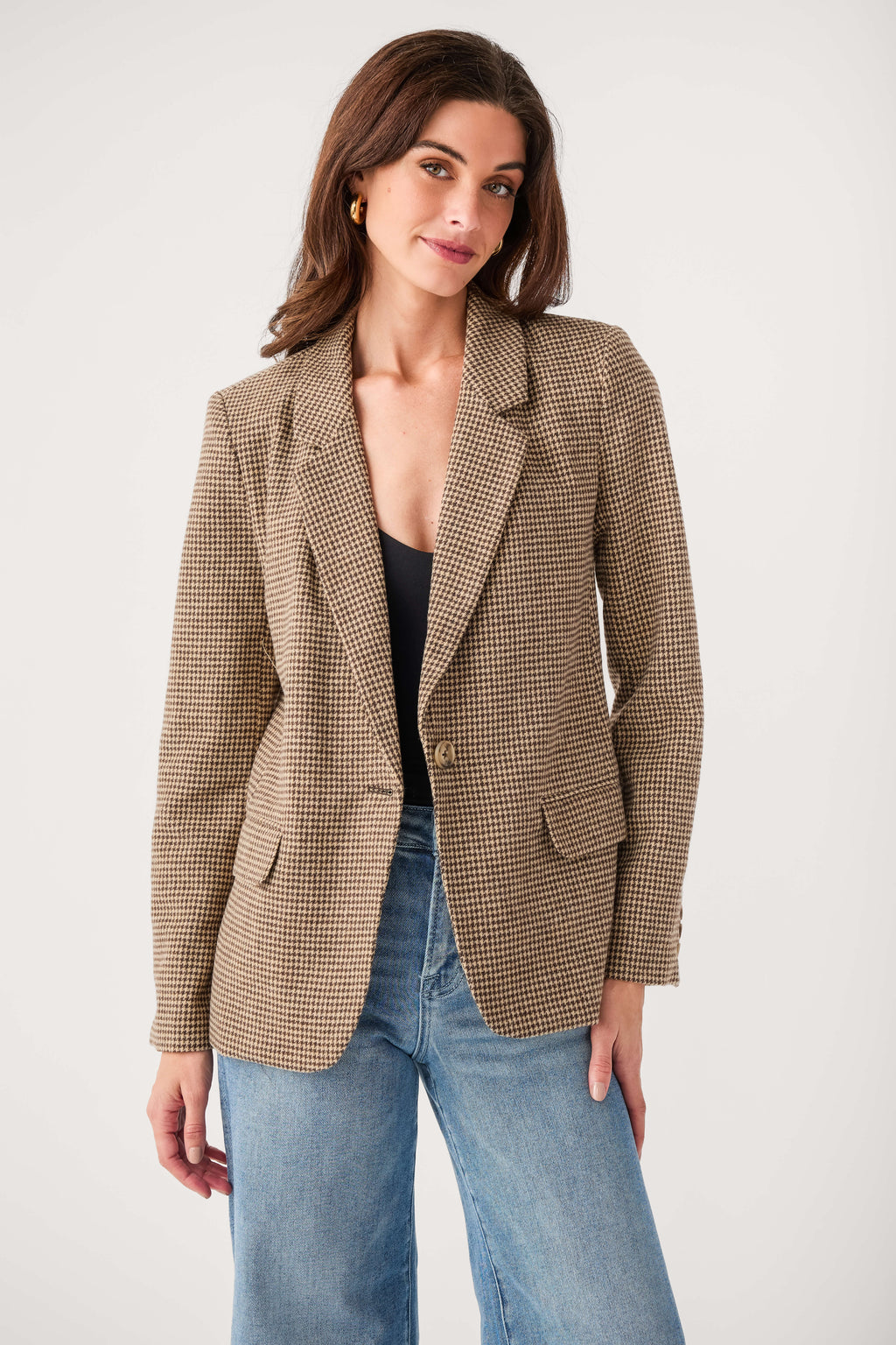 Brown check blazer with notch lapels and flap pockets, worn over jeans