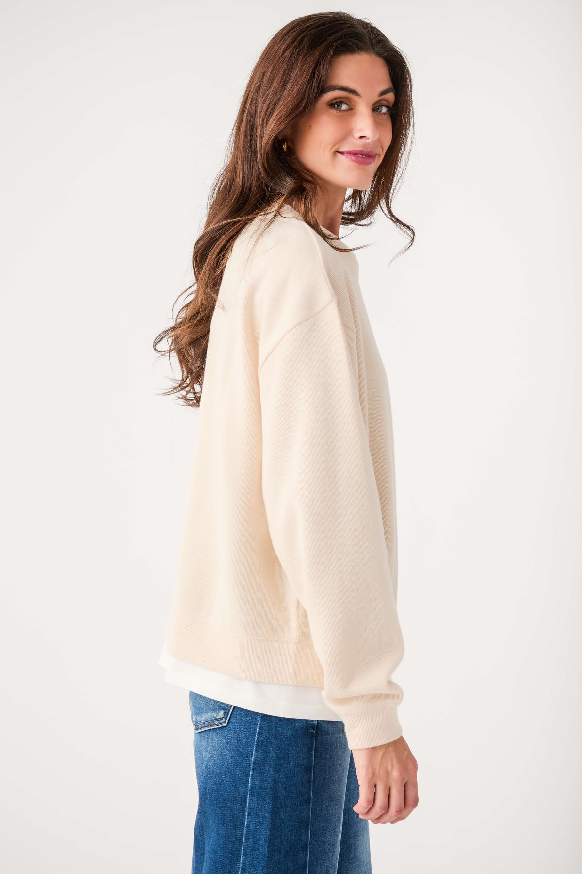 Cream crewneck pullover with long sleeves and ribbed cuffs and hem