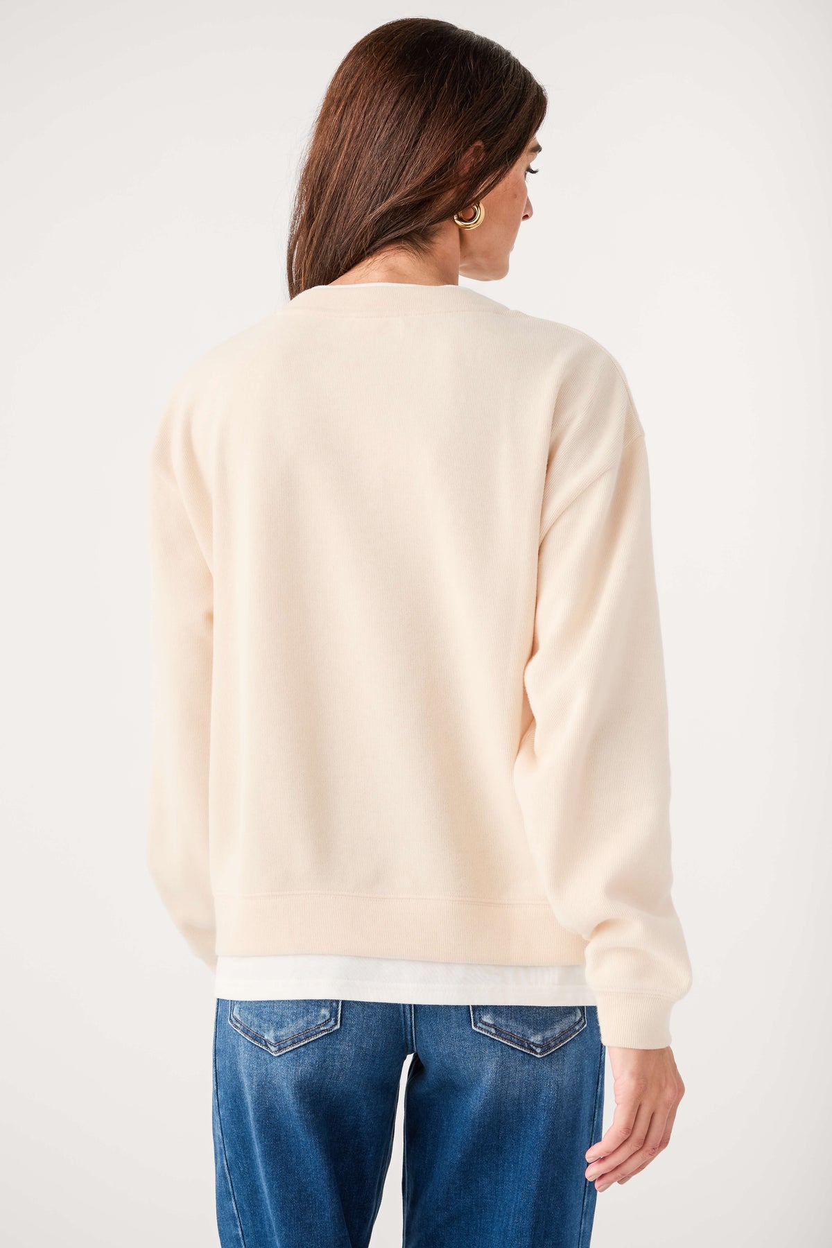 Back view of cream crewneck pullover sweater with ribbed cuffs