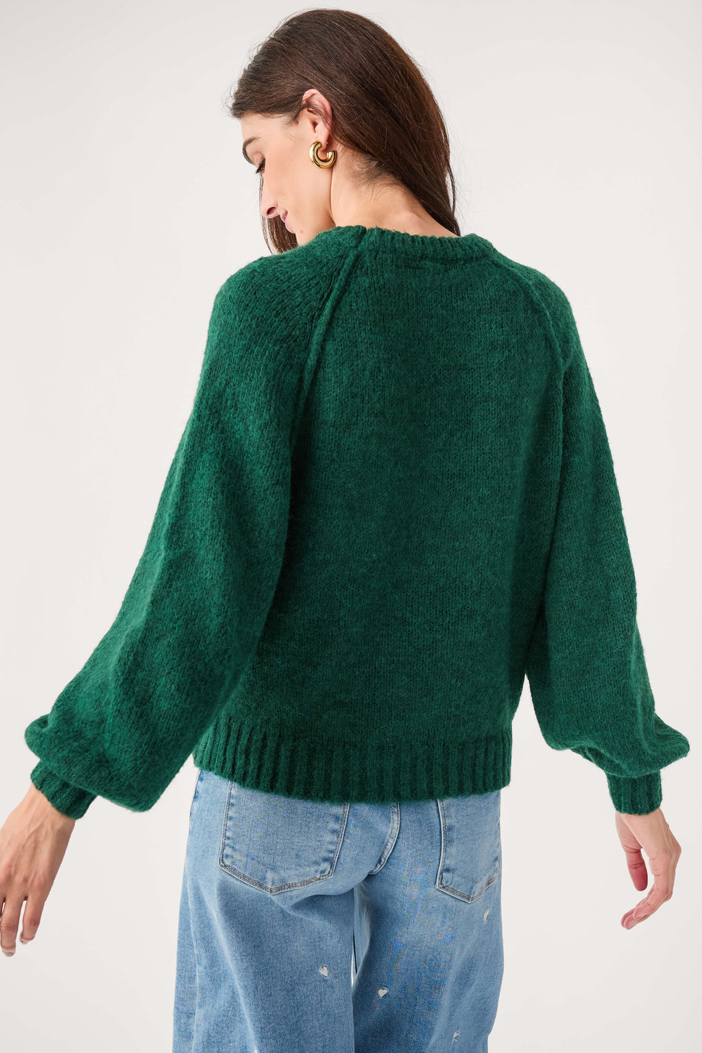 Forest green raglan sleeve sweater shown from back with ribbed cuffs and hem
