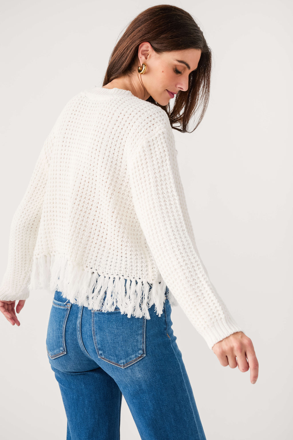 White knit crewneck sweater with frayed fringe hem, back/side view and long sleeves