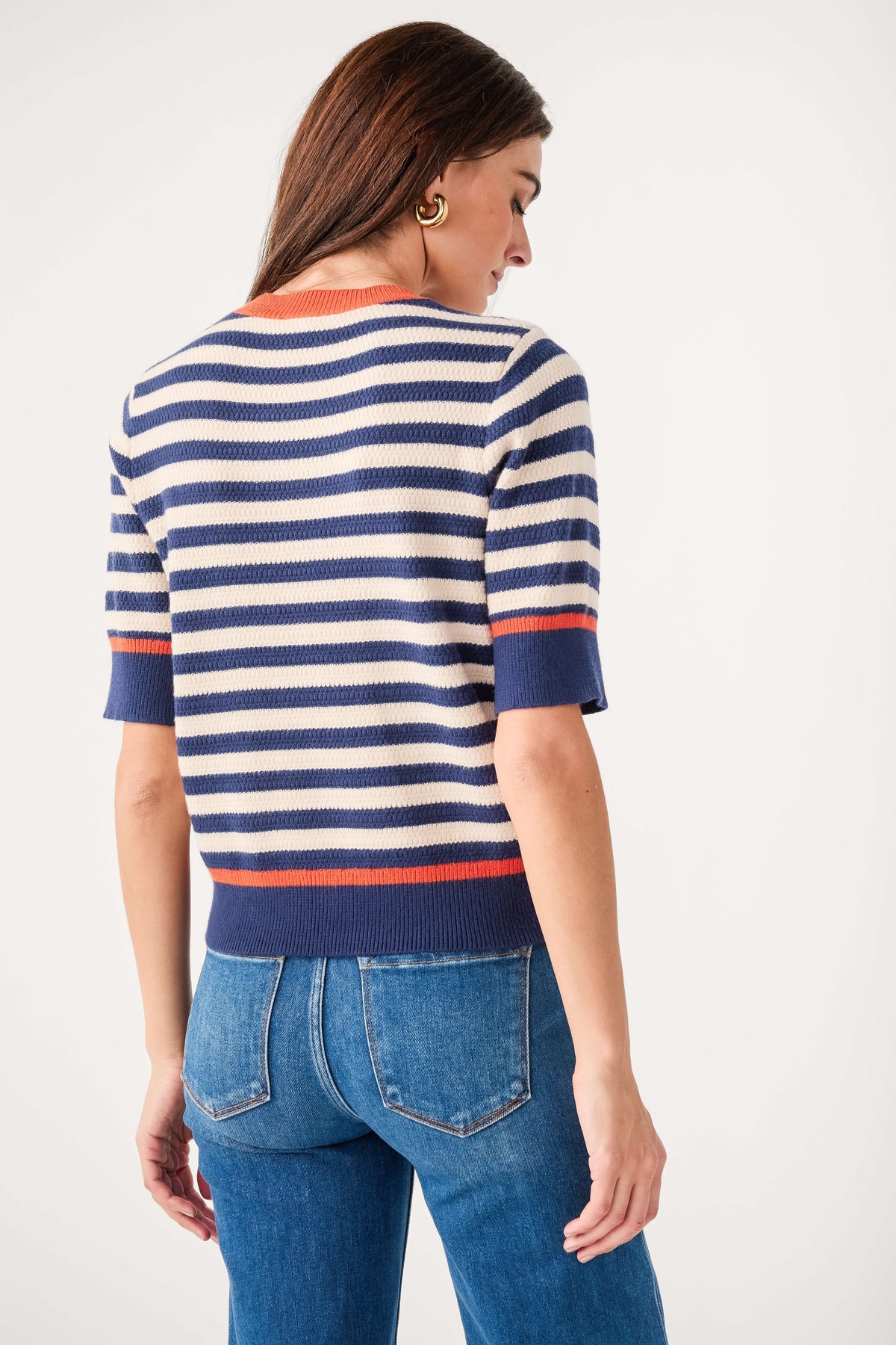 Navy striped knit top with crew neck and orange-red hem stripe; back view
