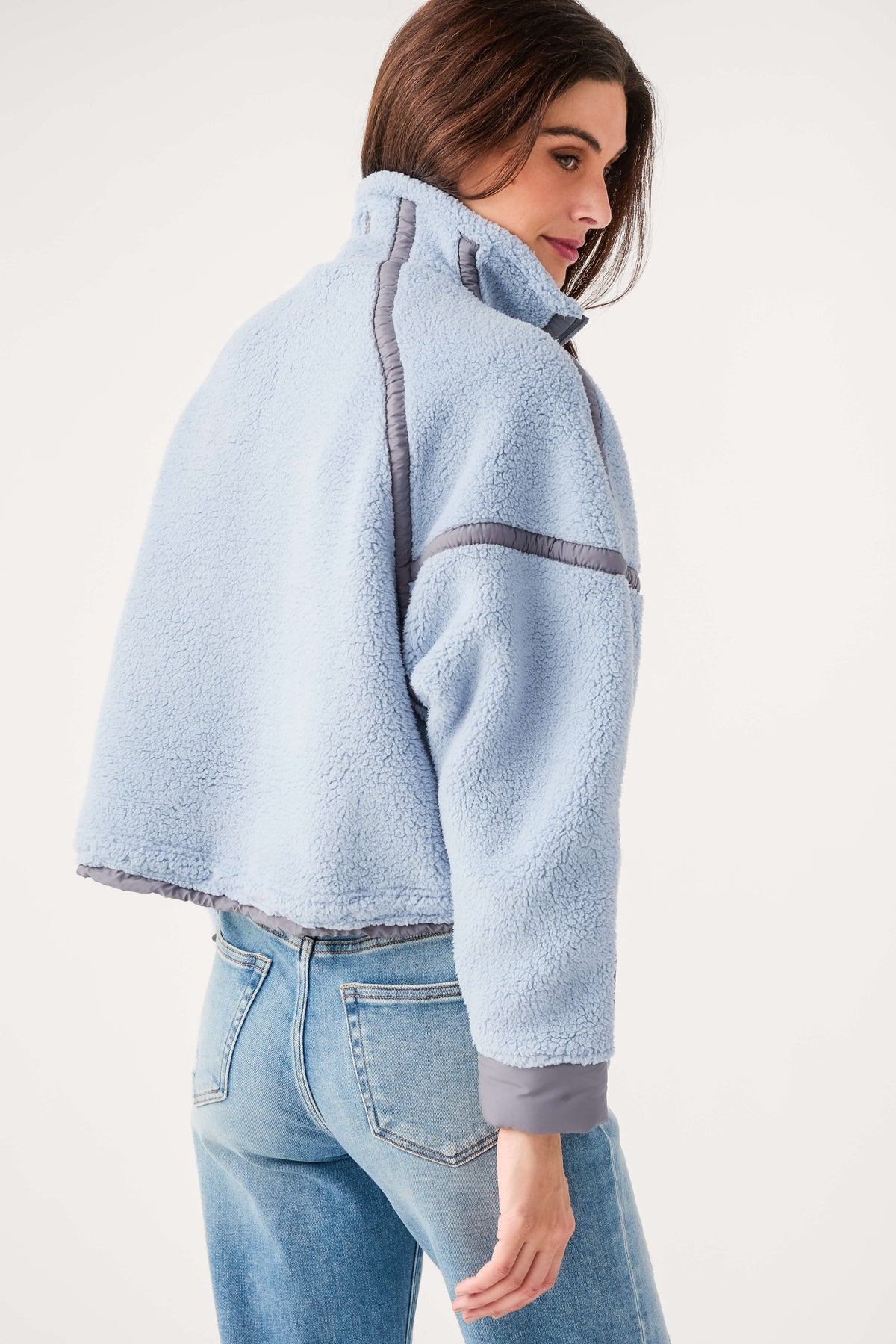 Light blue fleece 1/2-zip pullover with gray contrast pocket seam and long sleeves