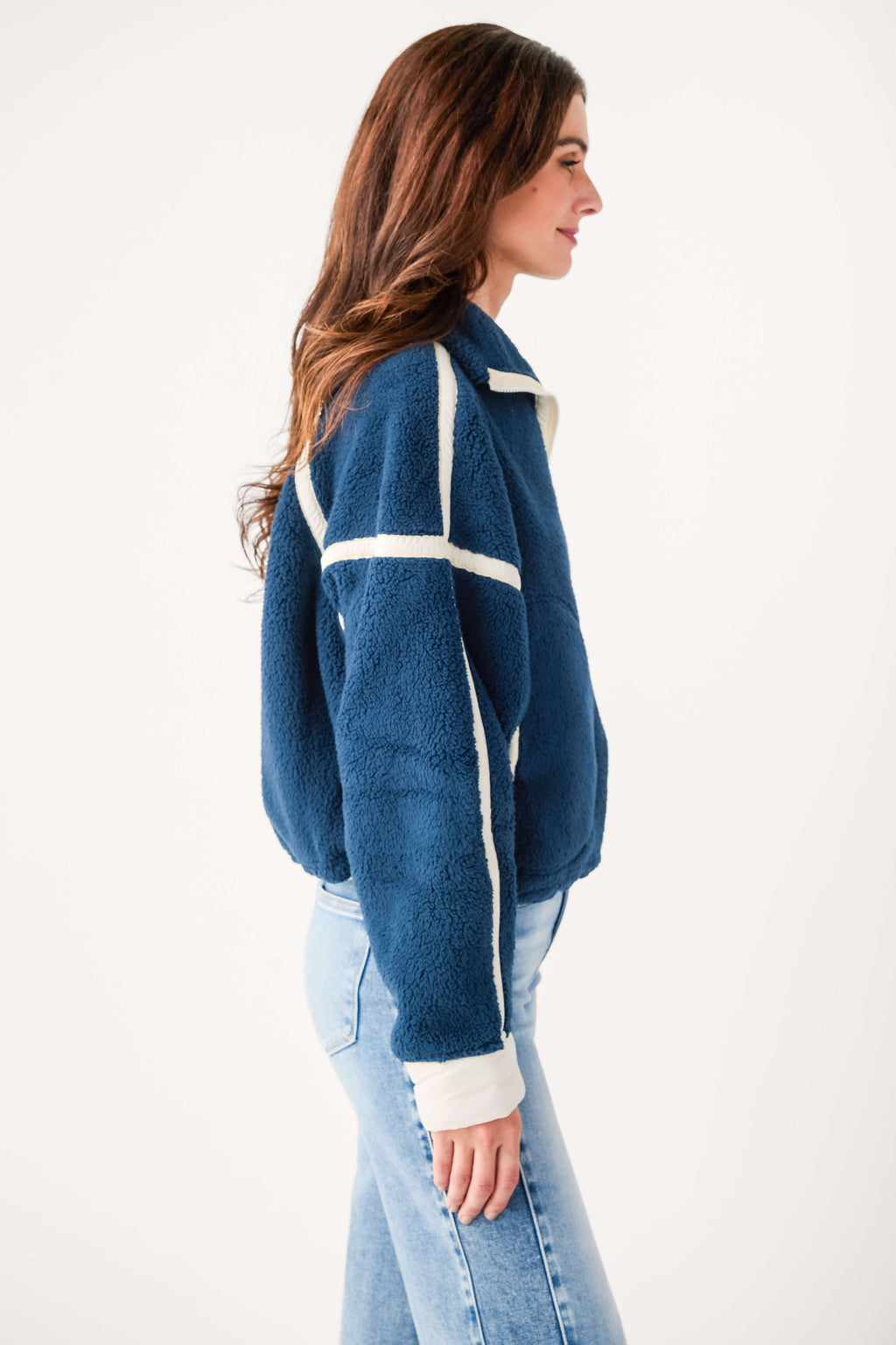 Blue jeans paired with white fleece 1/2-zip pullover featuring black contrast stripes