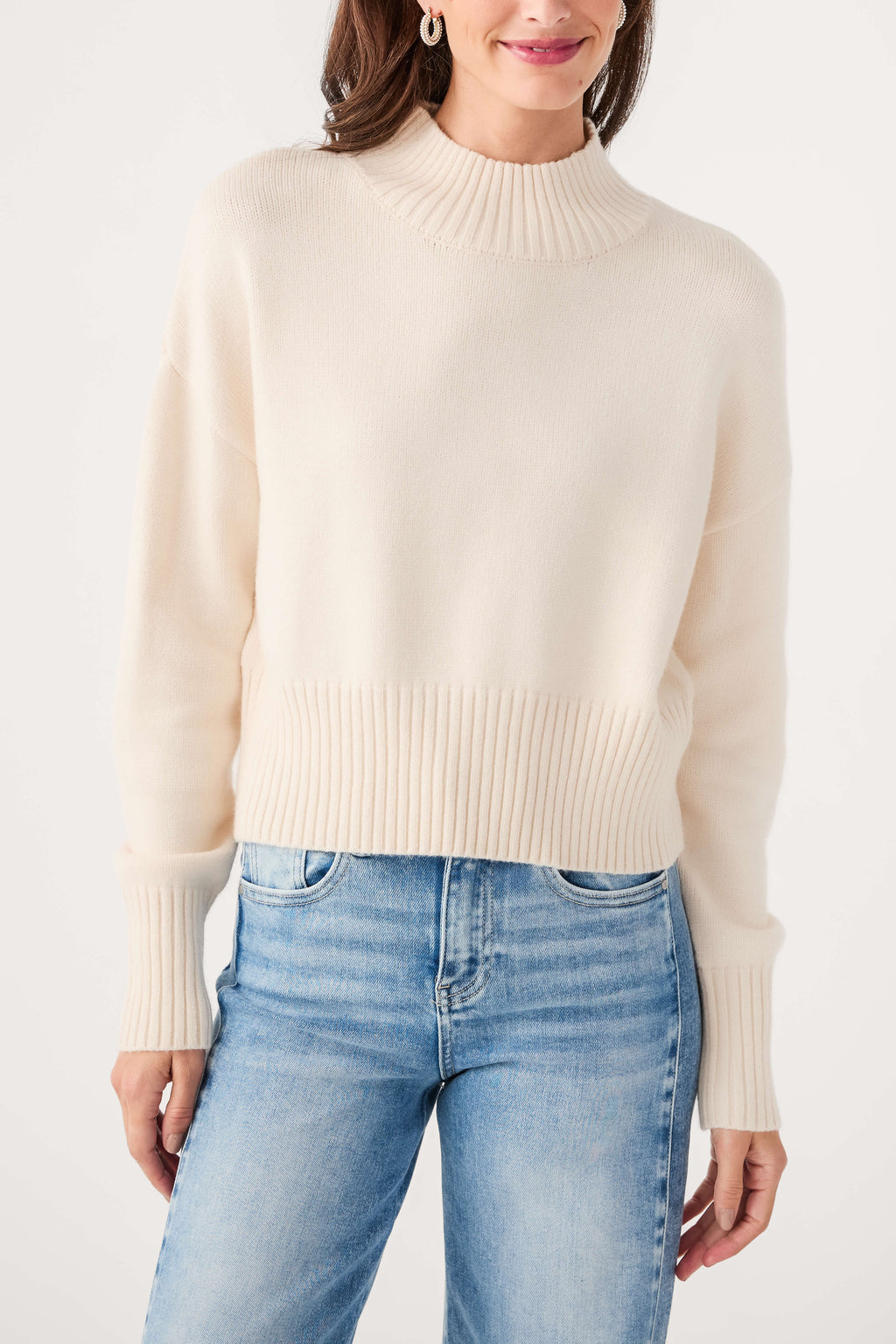 Ivory mock neck sweater with ribbed neckline and cuffs, knit texture detail