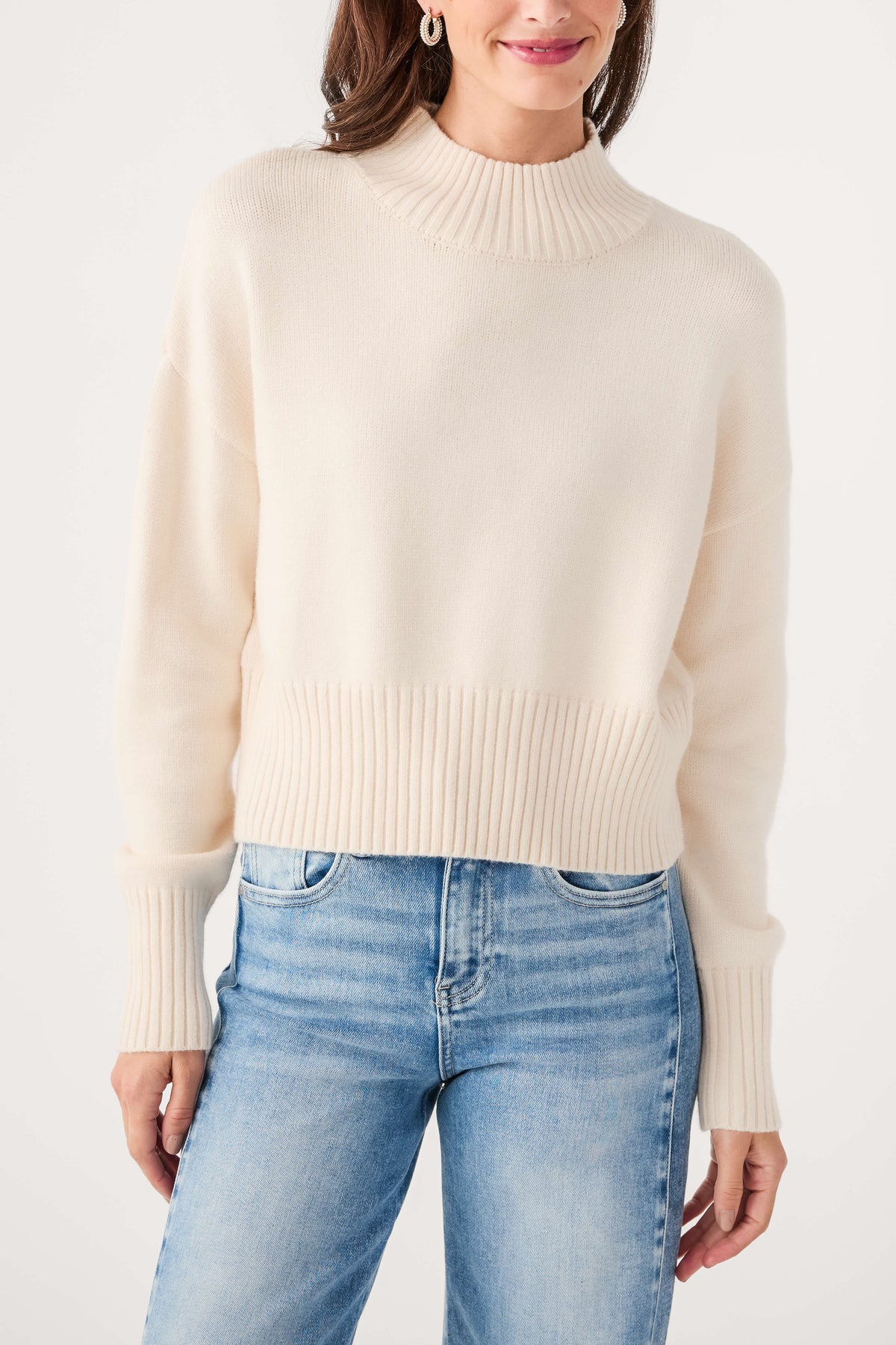 Ivory mock neck sweater with ribbed neckline and cuffs, knit texture detail
