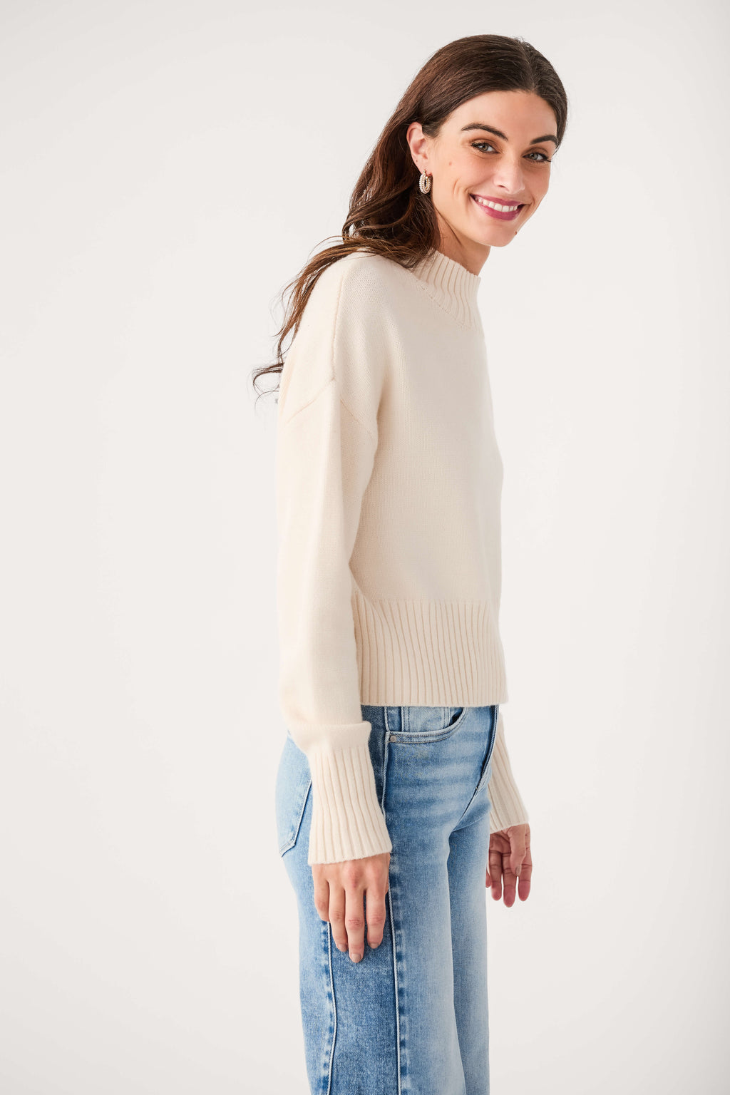 Ivory mock neck knit sweater, side view with ribbed cuffs and hem