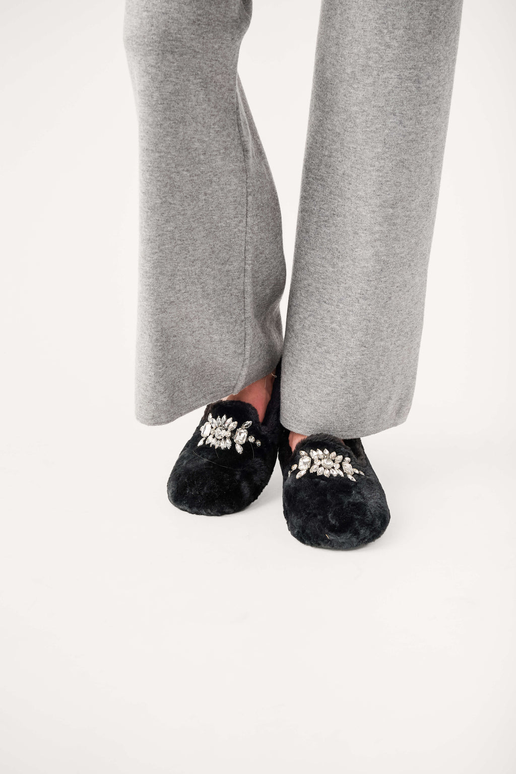 Black fuzzy loafer slippers with silver jeweled floral embellishment