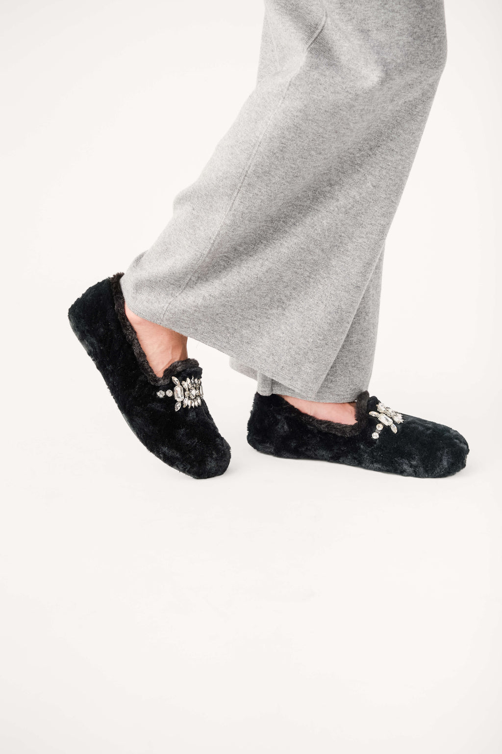 Black fuzzy loafer slippers with jeweled floral applique and bow detail