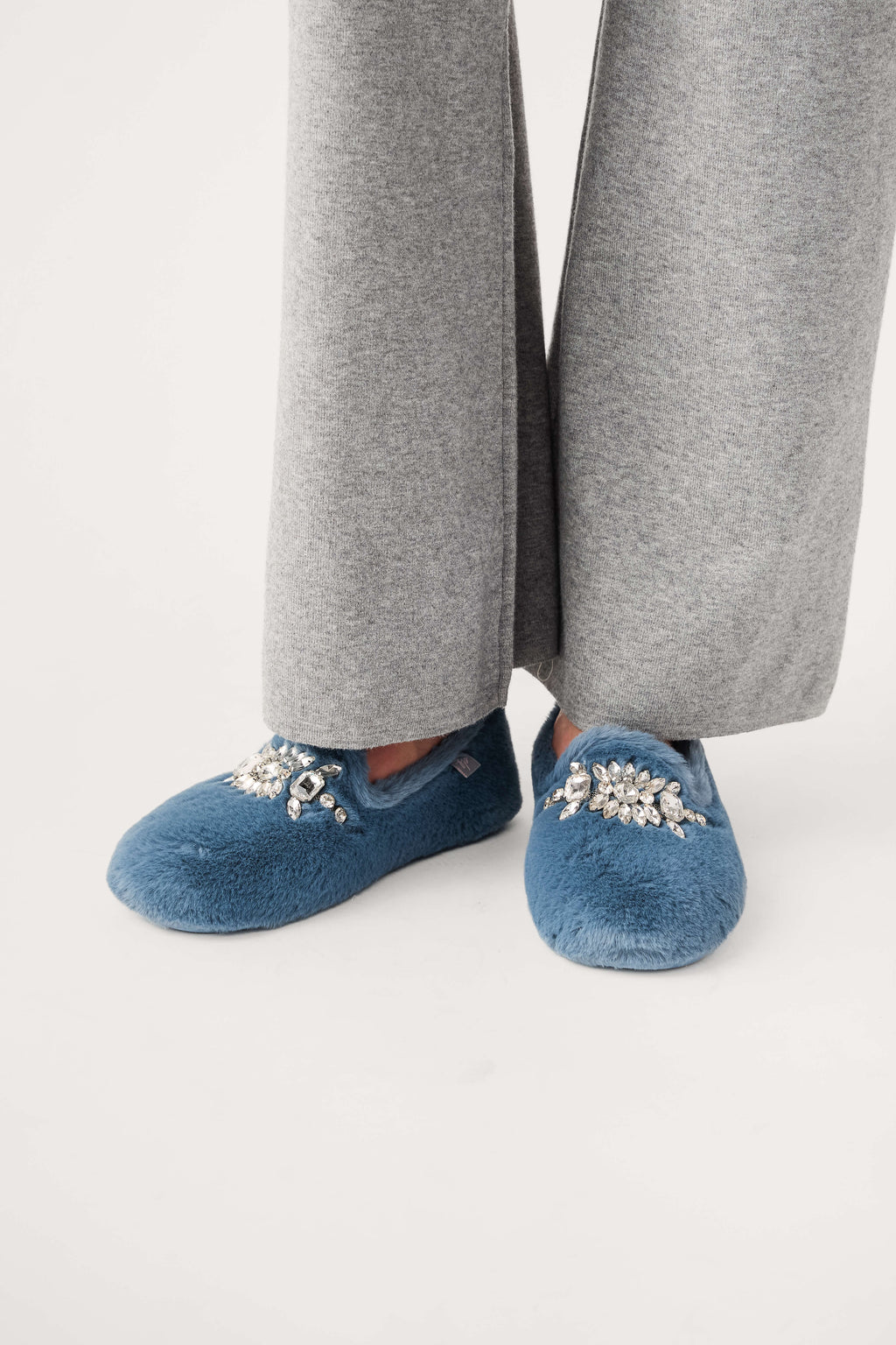 Blue fuzzy loafer slippers with jeweled floral applique and rounded toe