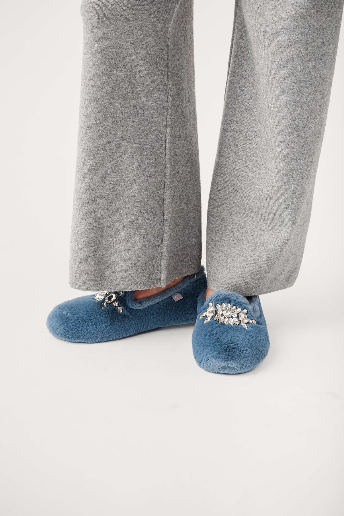 Blue fuzzy loafer slippers with jeweled floral detail and rounded toe