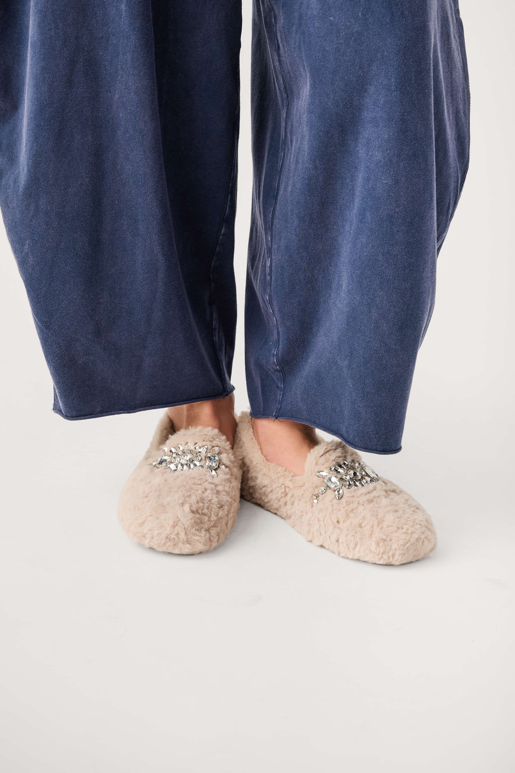 Beige fuzzy loafer slippers with jeweled floral embellishment and slip-on fit