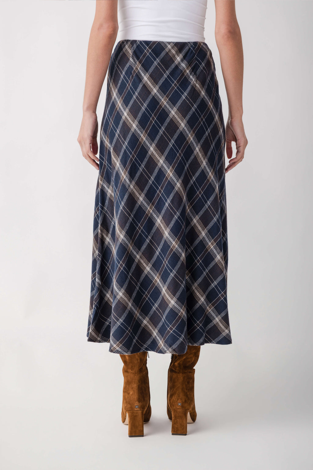 Navy plaid midi skirt with cream diagonal lines worn with tan suede boots.