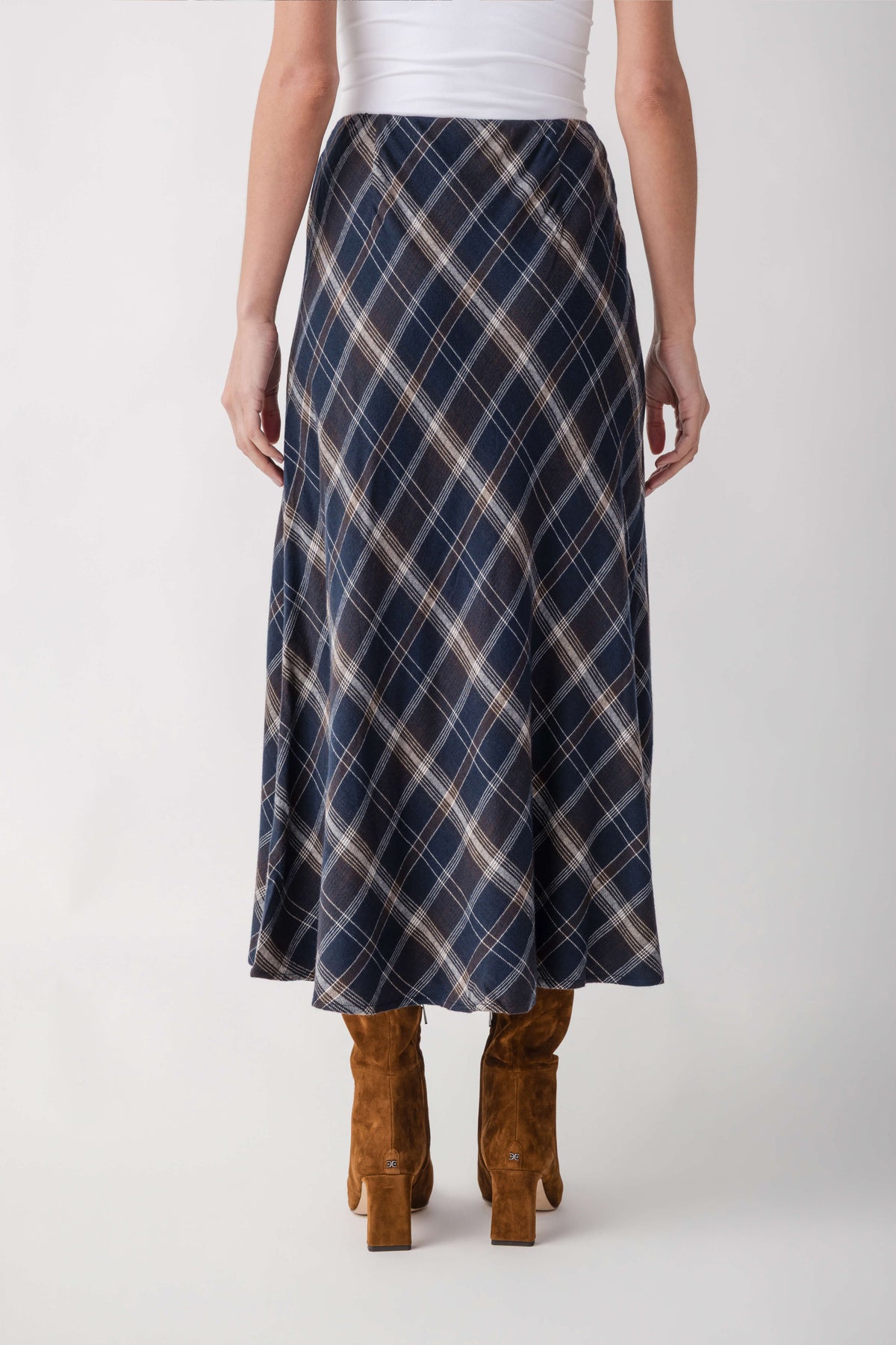 Navy plaid midi skirt with cream diagonal lines worn with tan suede boots.