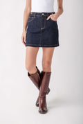 Dark blue denim mini skirt with front pockets and contrasting topstitching on model wearing burgundy boots.