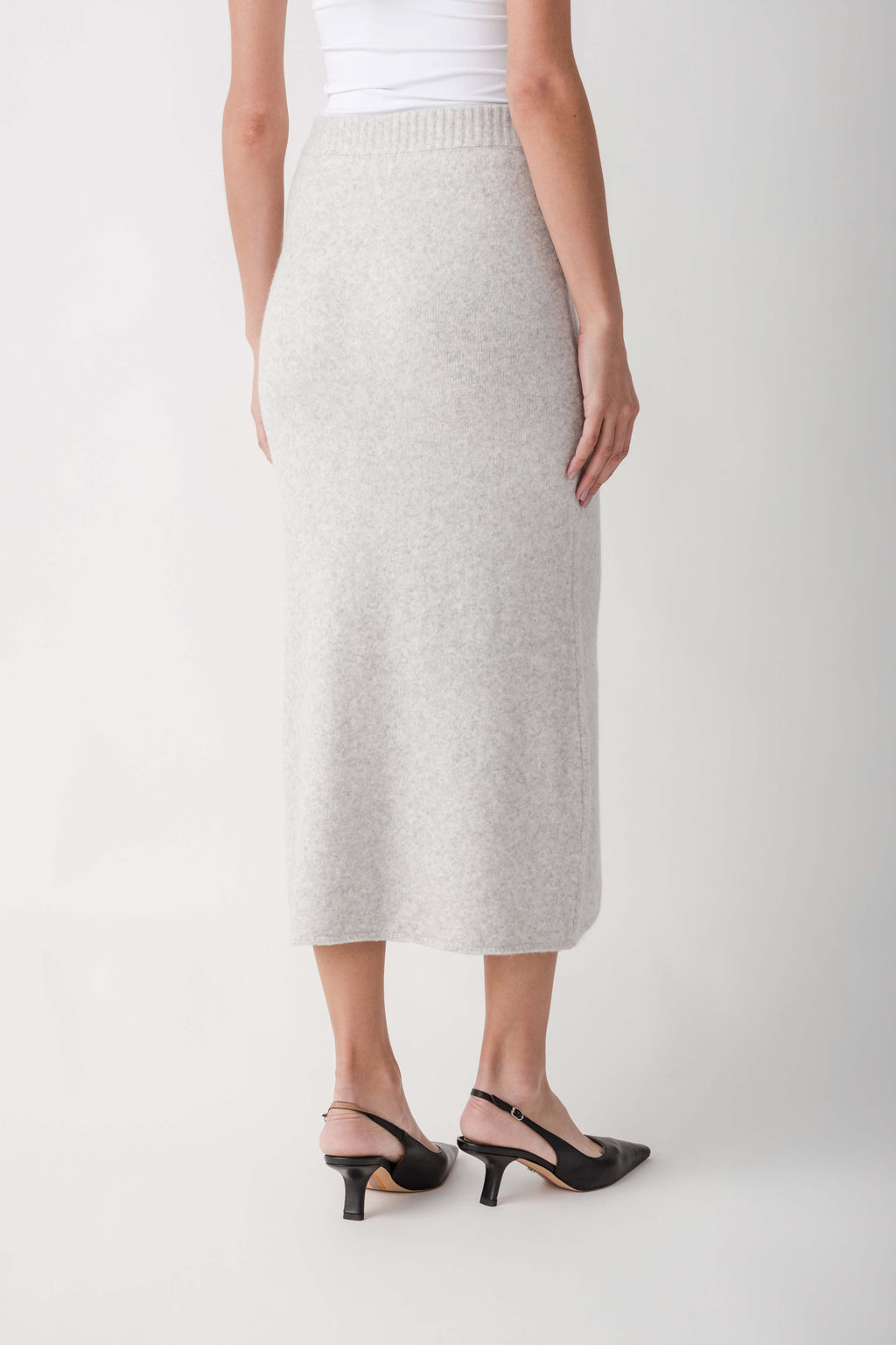 Cream ribbed midi skirt with elastic waistband worn with white tank top and black slingback heels.
