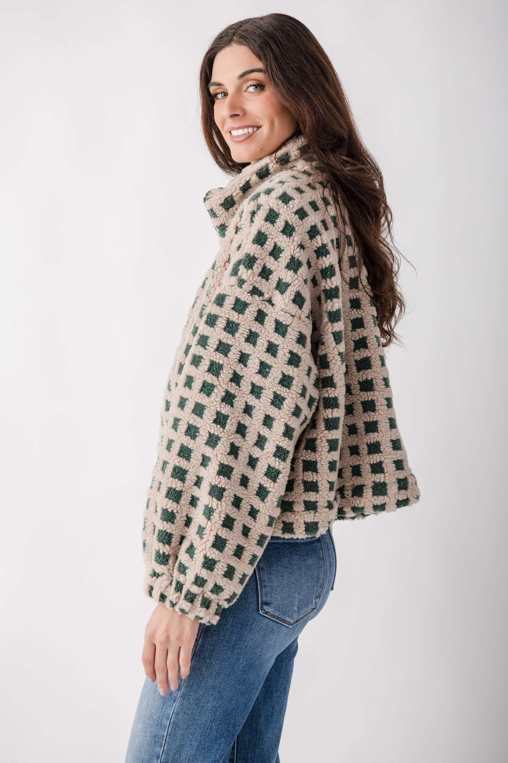 Cream and green check sherpa fleece jacket worn over blue jeans, shown from the side on a model.