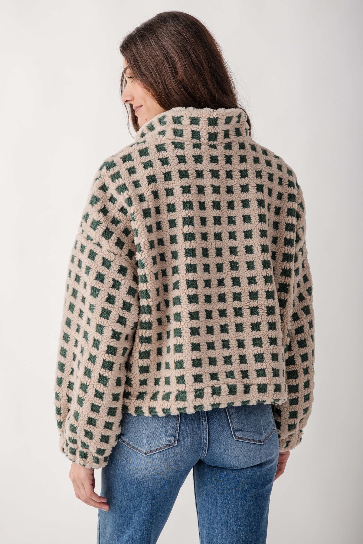 Cream and green check sherpa fleece jacket on model wearing blue jeans, back view.