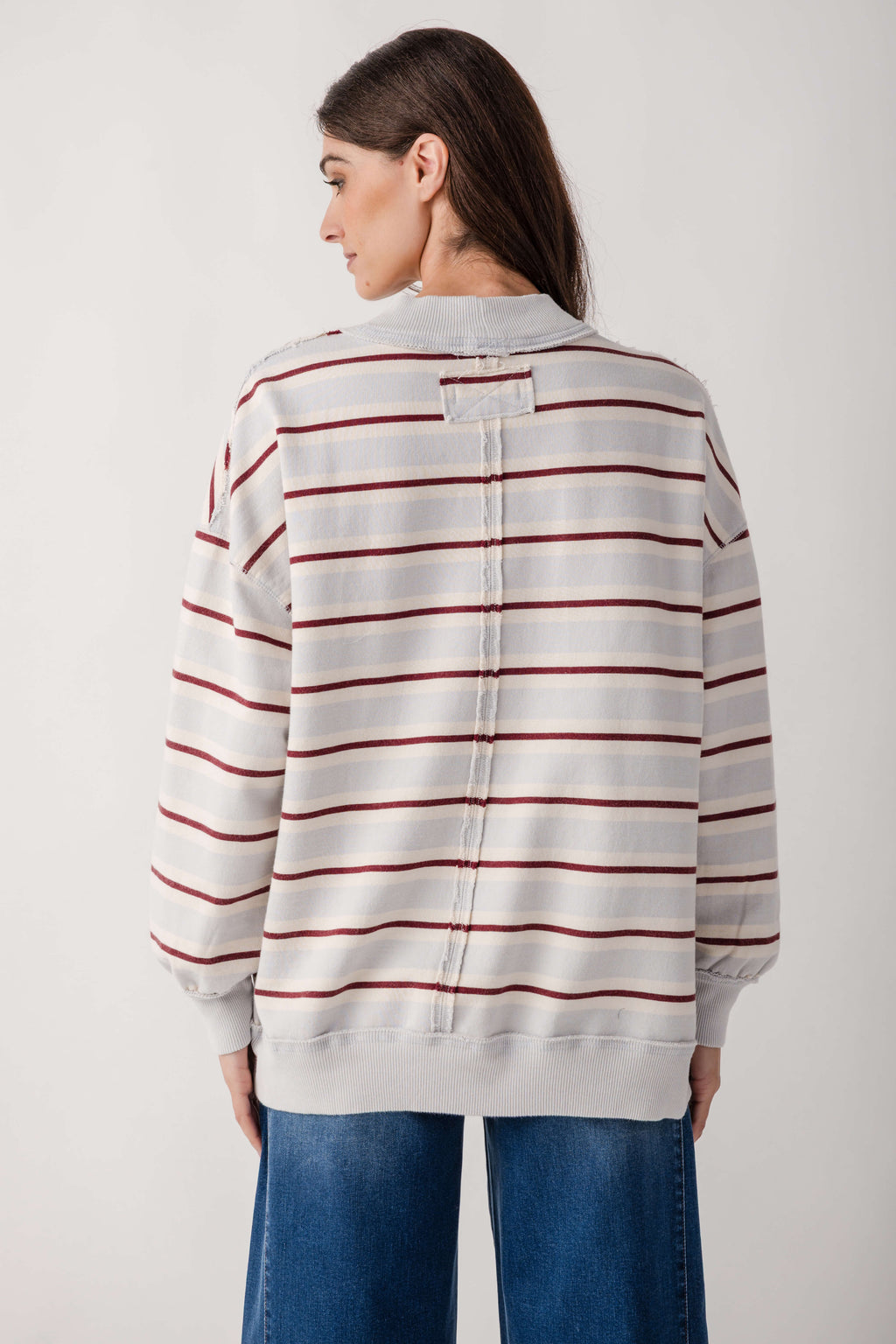 Cream and burgundy striped pullover sweater with ribbed collar and cuffs, shown from back on model wearing jeans.