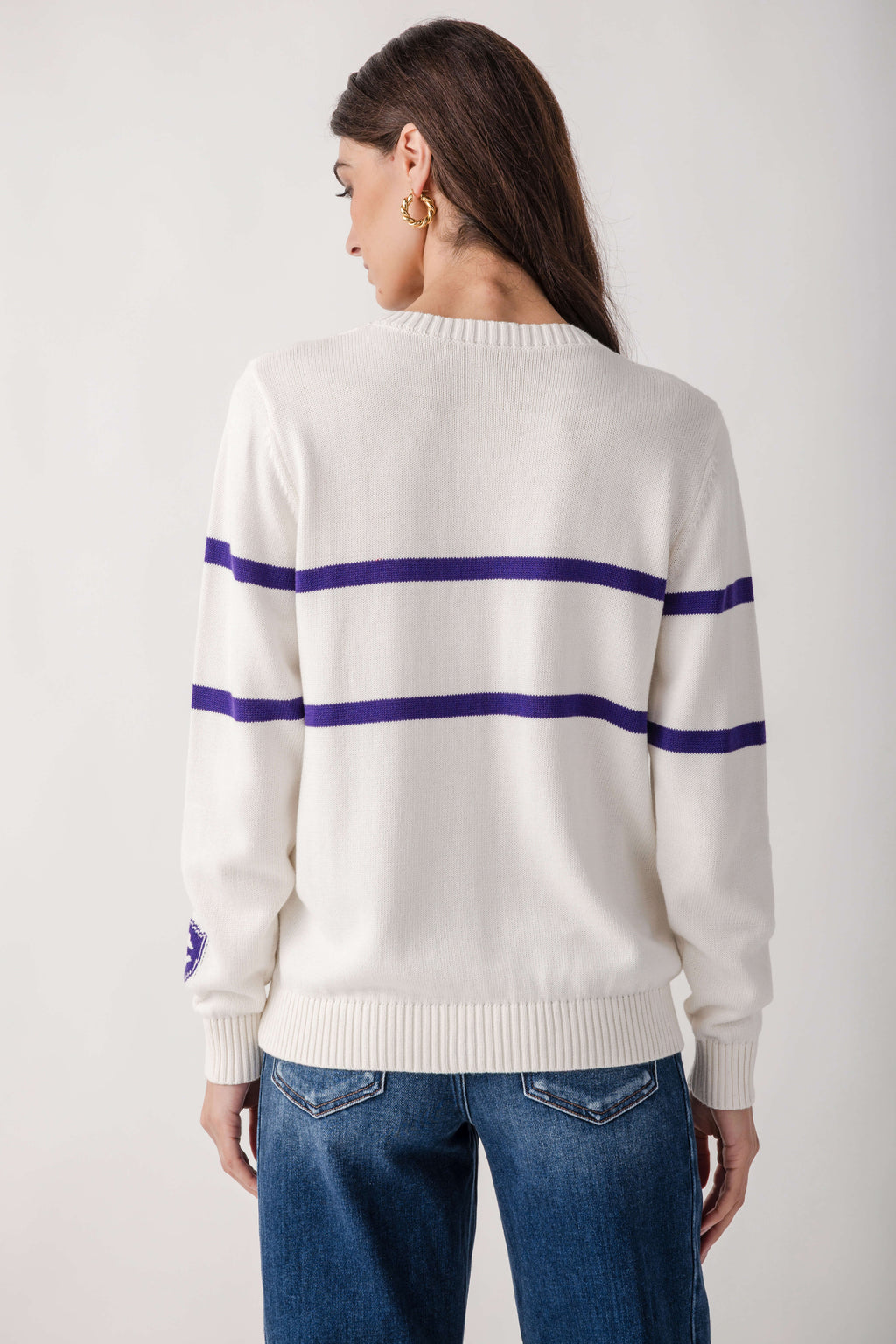 Cream sweater with navy horizontal stripes across chest and sleeves, worn with blue jeans.