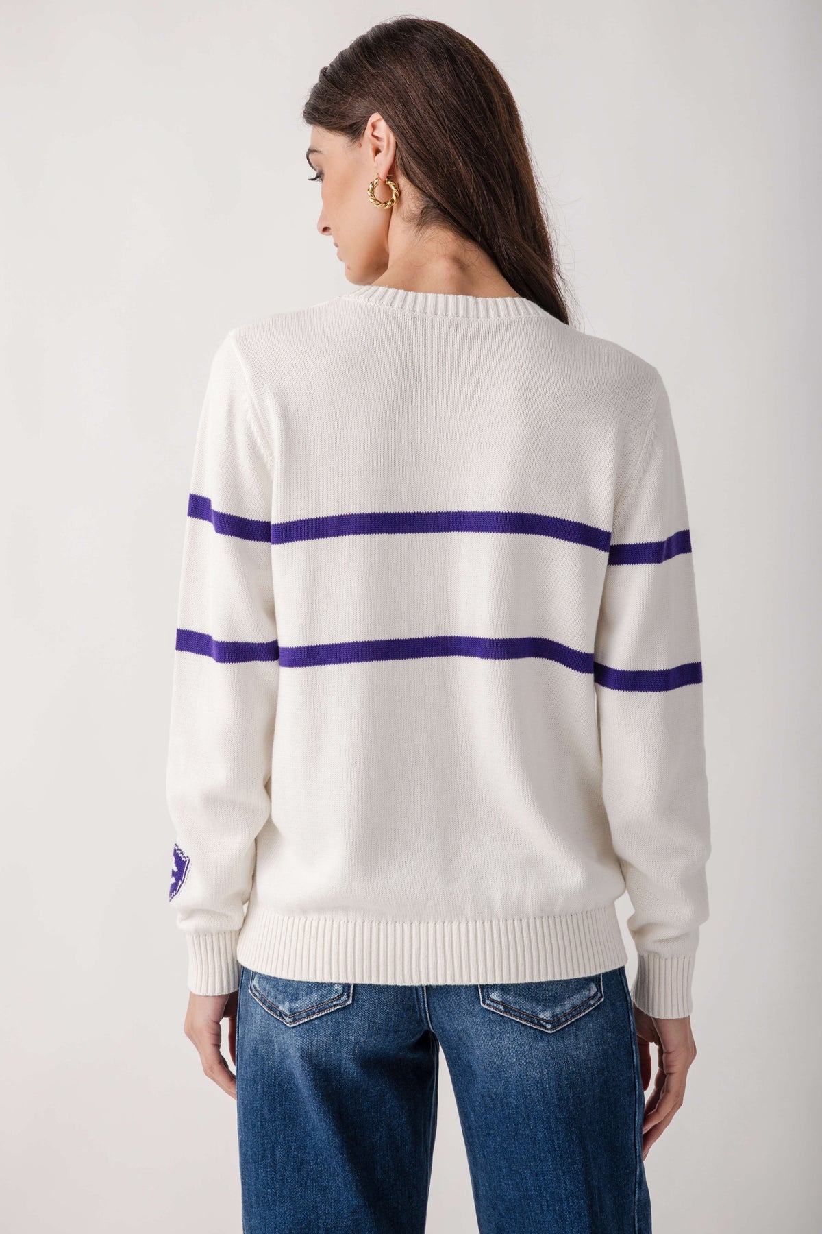Cream sweater with navy horizontal stripes across chest and sleeves, worn with blue jeans.